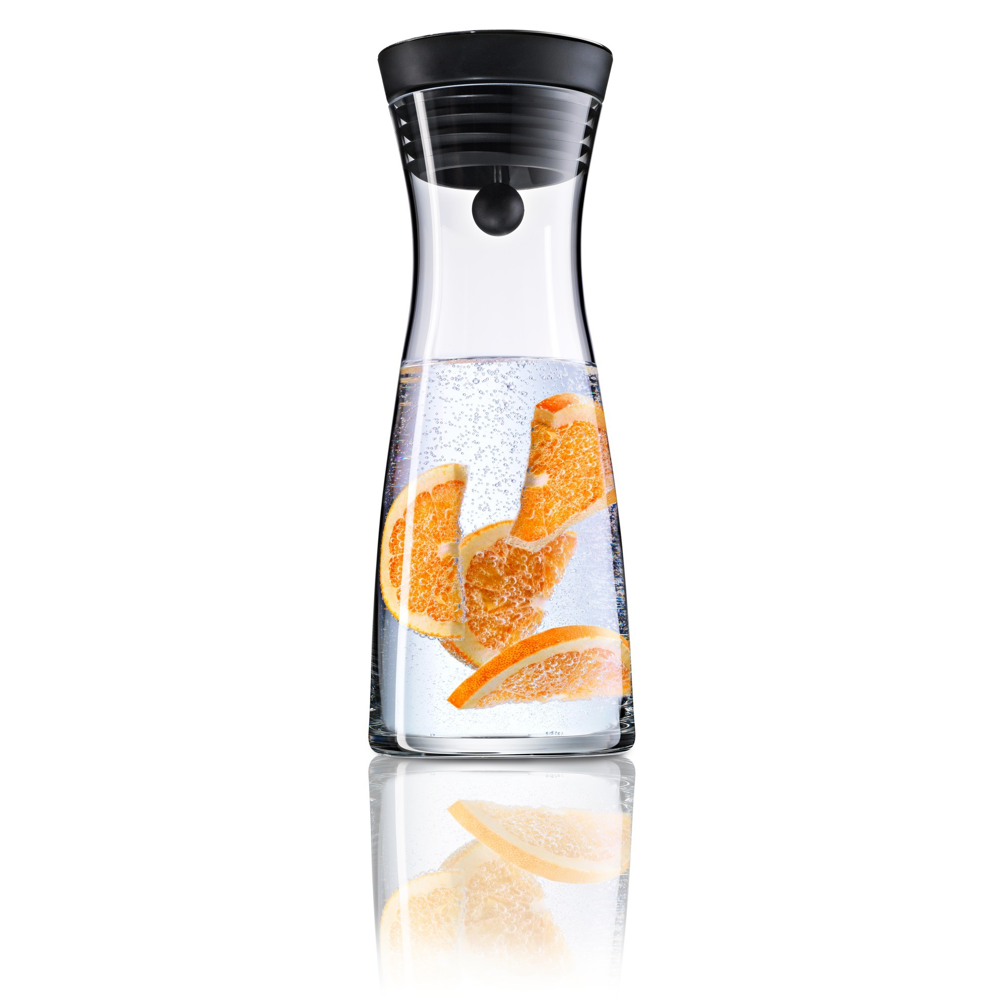 Eine Glaskaraffe mit Wasser und Orangenscheiben gefüllt. Ein schwarzer Deckel sitzt obenauf.