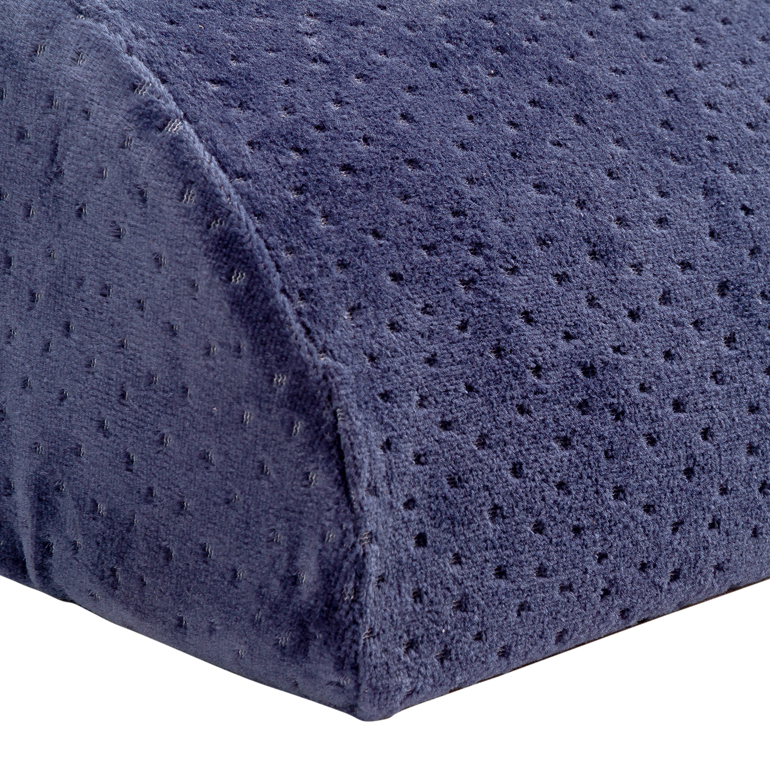 Primer plano de una almohada azul marino con una superficie texturizada. Tiene una forma ligeramente angular y está bien iluminada.