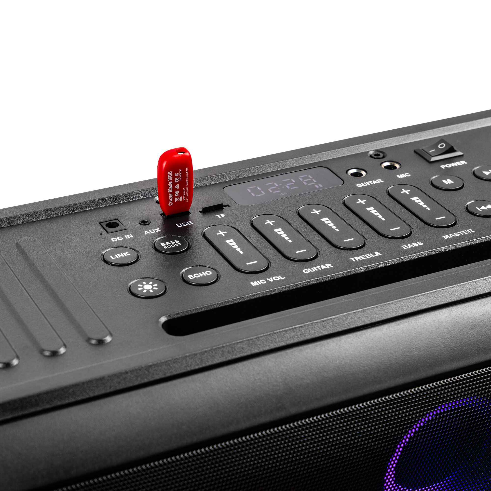 Panel de control del altavoz con botones y una unidad USB insertada. Los botones incluyen: AUX, Mic Vol, Guitarra, Master.