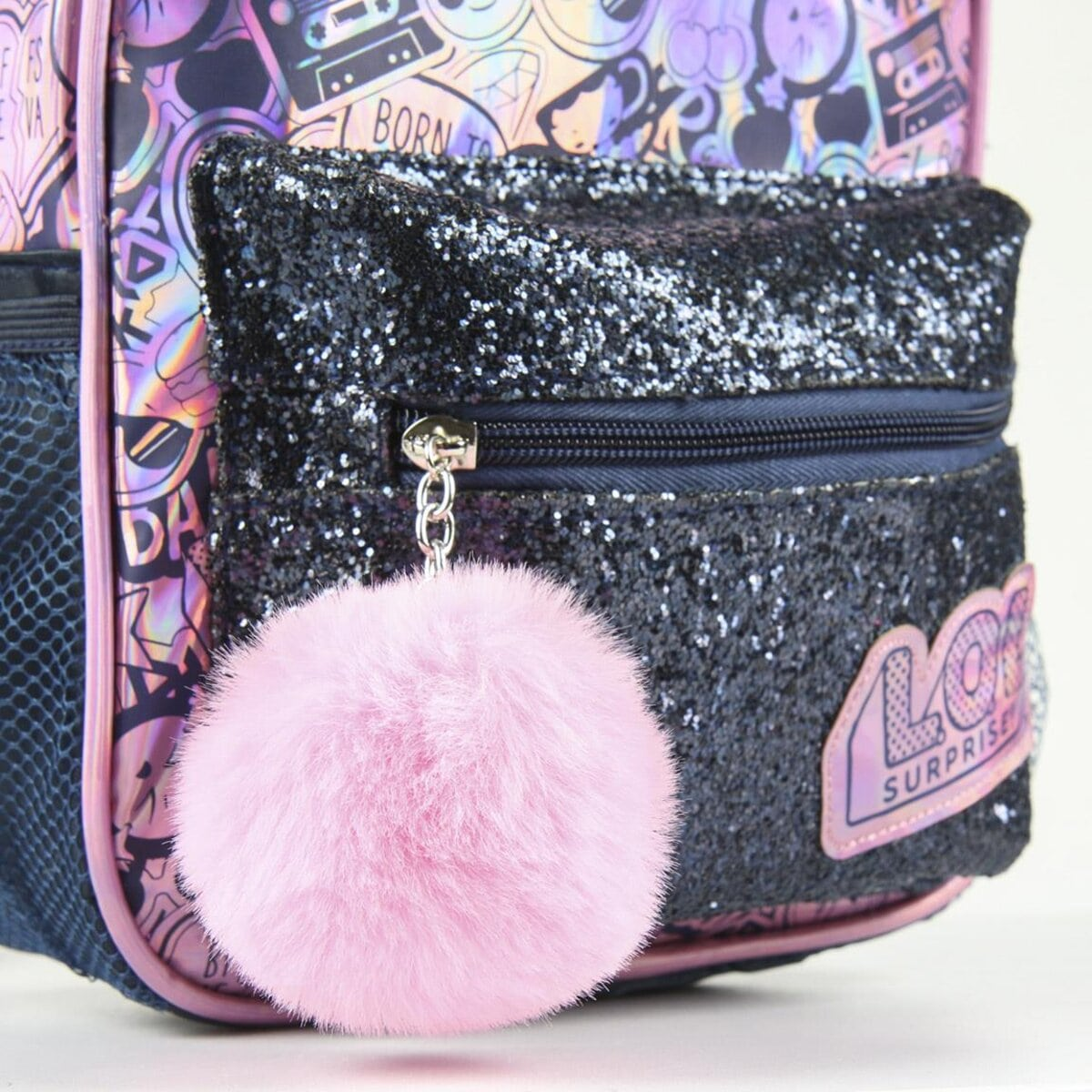 Una mochila azul marino con un bolsillo brillante y un pompón rosa. La bolsa tiene diseños coloridos y un parche 'LOL Surprise'.