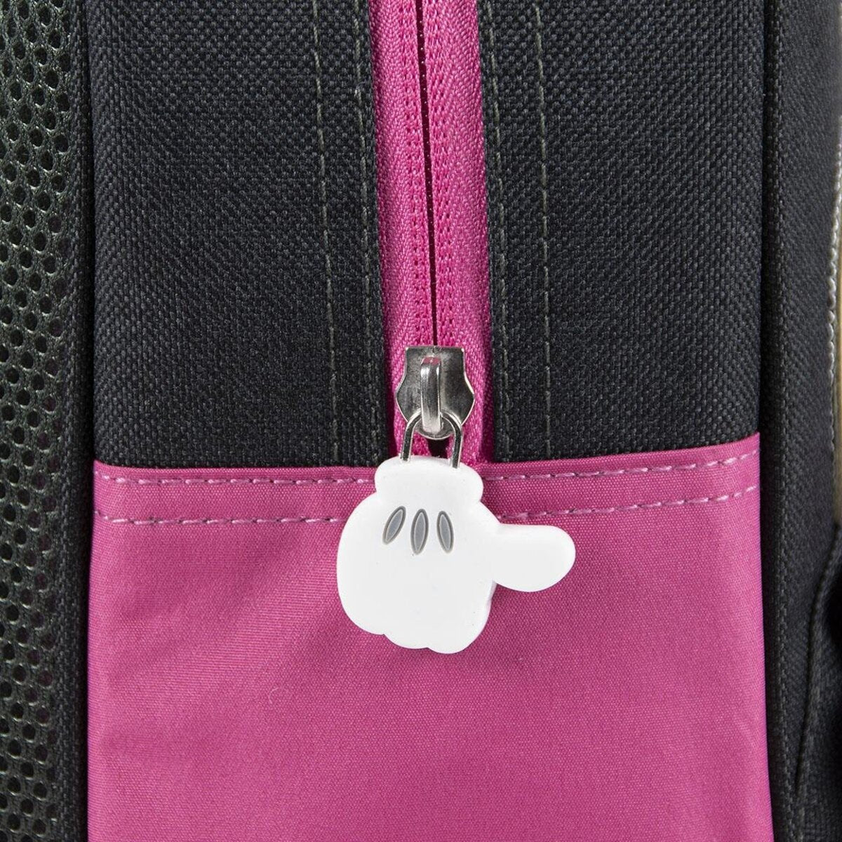 Primer plano del tirador de la cremallera de una mochila de Minnie Mouse. El tirador es una mano blanca de Mickey Mouse.