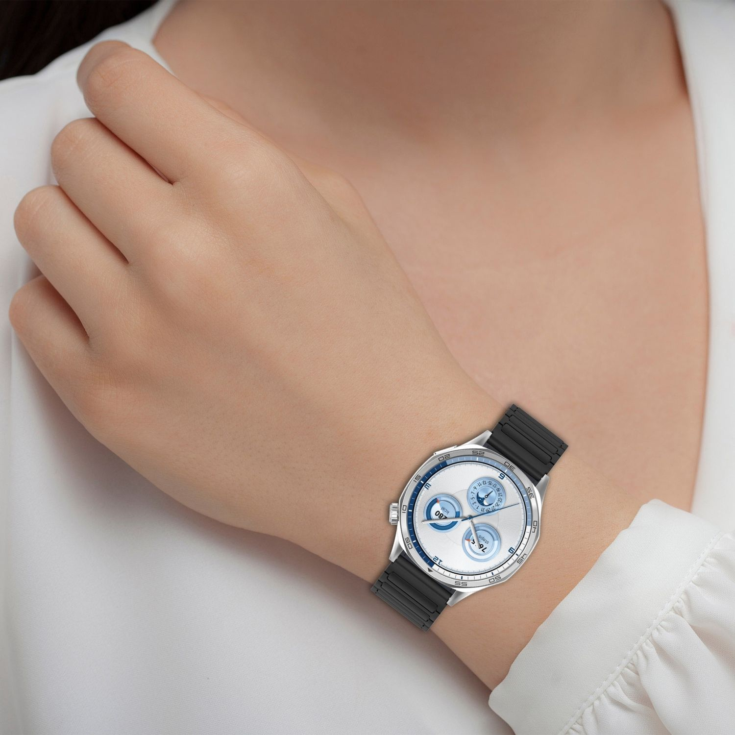 Das Handgelenk einer Frau mit einer Uhr. Die Uhr hat ein silbernes Gehäuse, ein schwarzes Band und blaue Akzente.