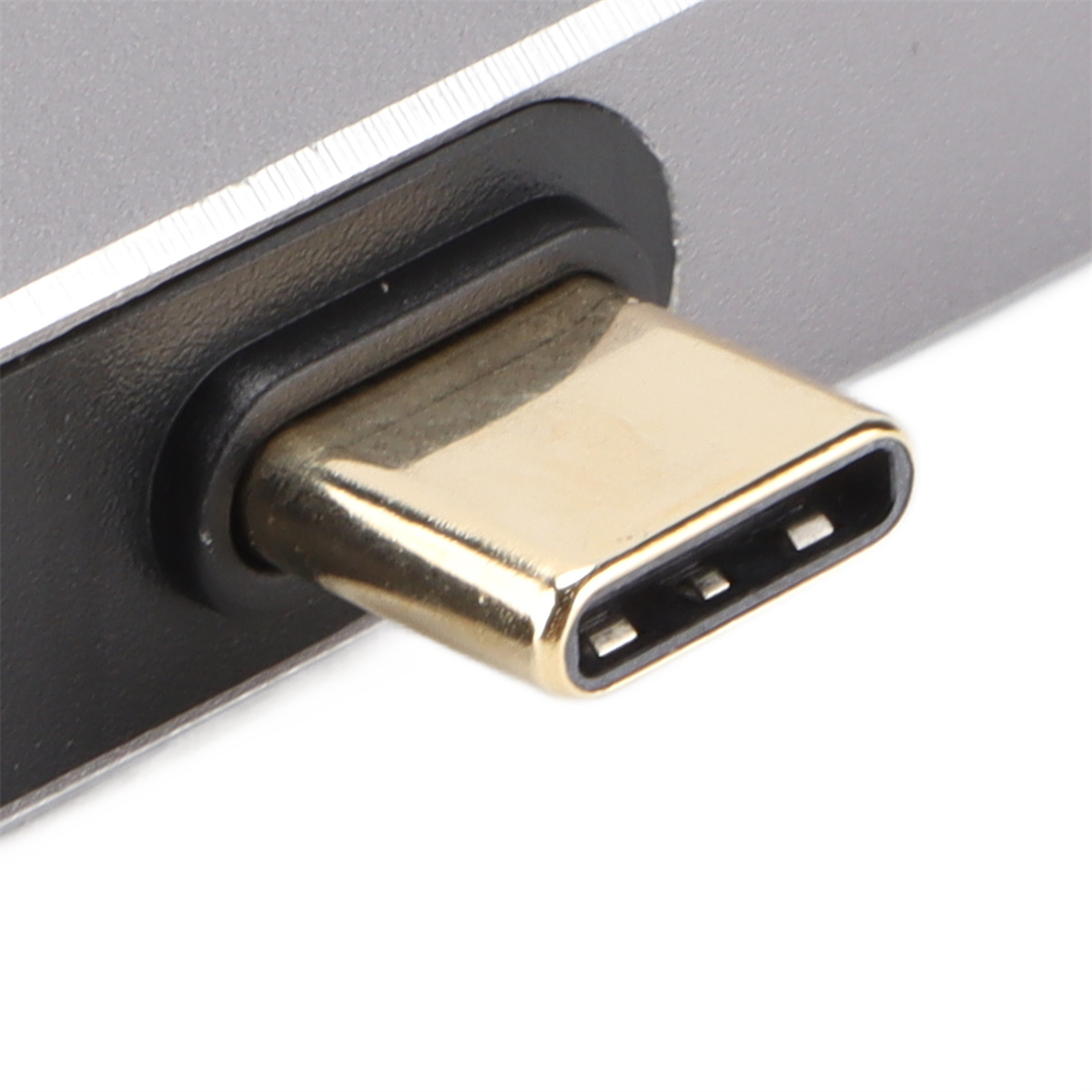 Nahaufnahme eines goldfarbenen USB-C-Anschlusses mit drei Pins an einem grauen Gerät.