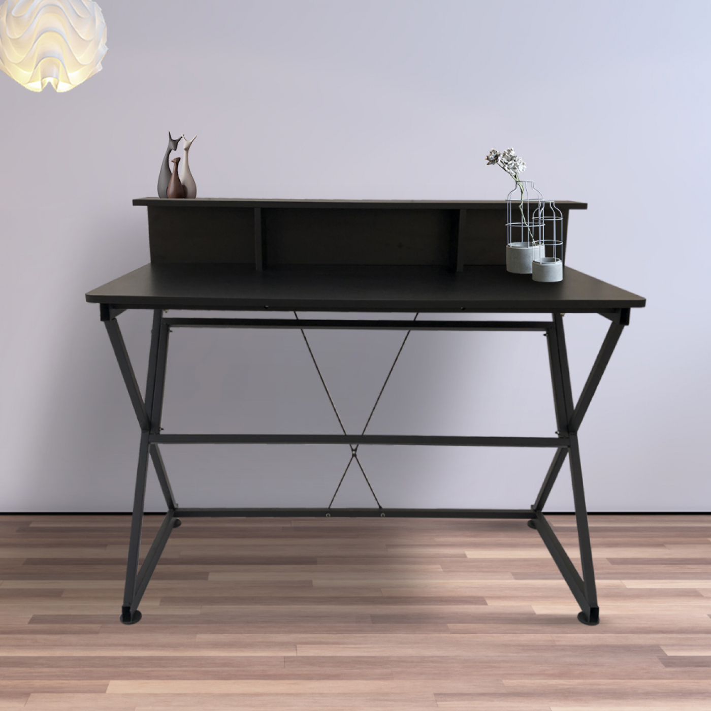 Zwarte bureau met een plank. Een lamp hangt erboven. Twee vazen met bloemen staan rechts.