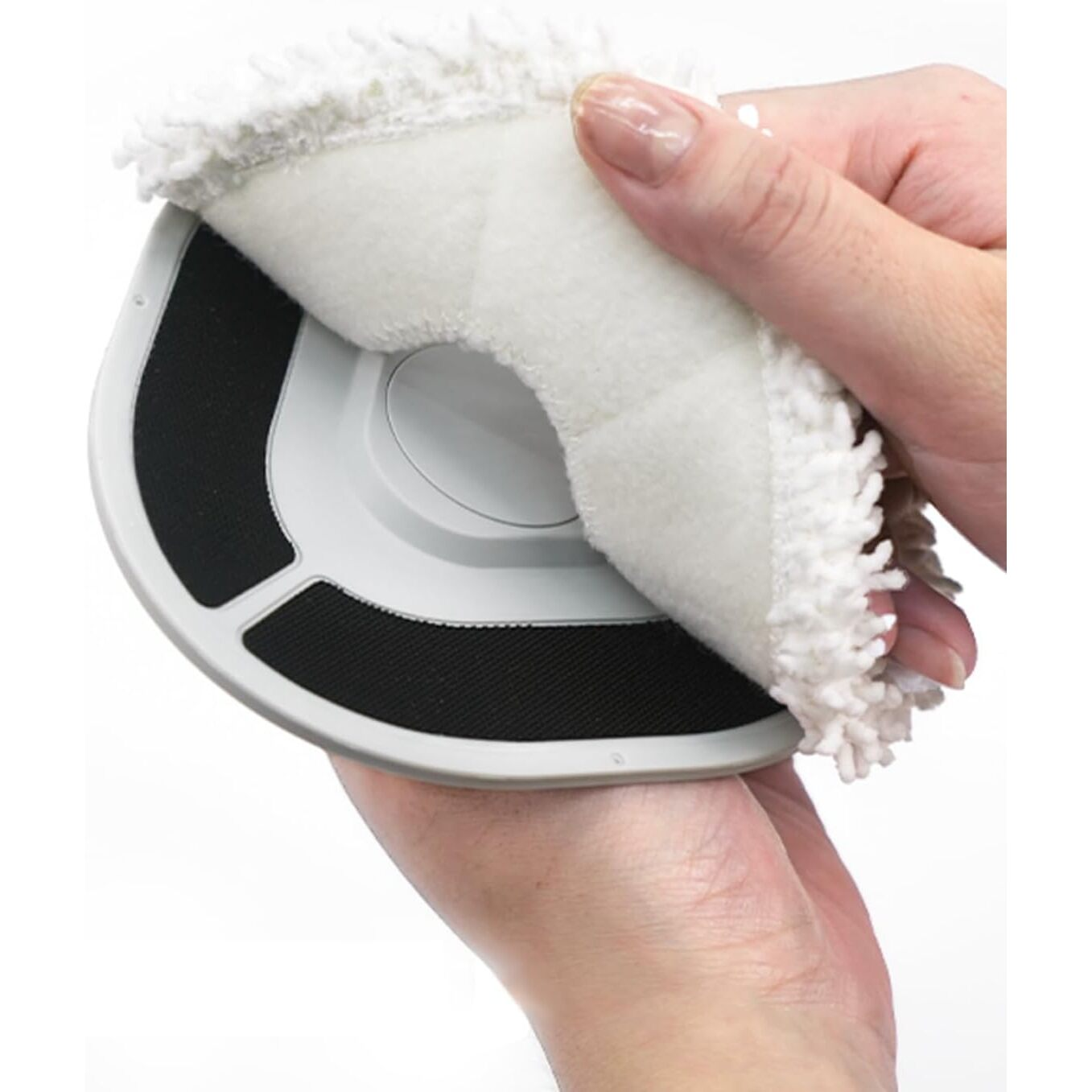 Una mano che tiene un oggetto bianco rotondo con sezione nera e tampone bianco.