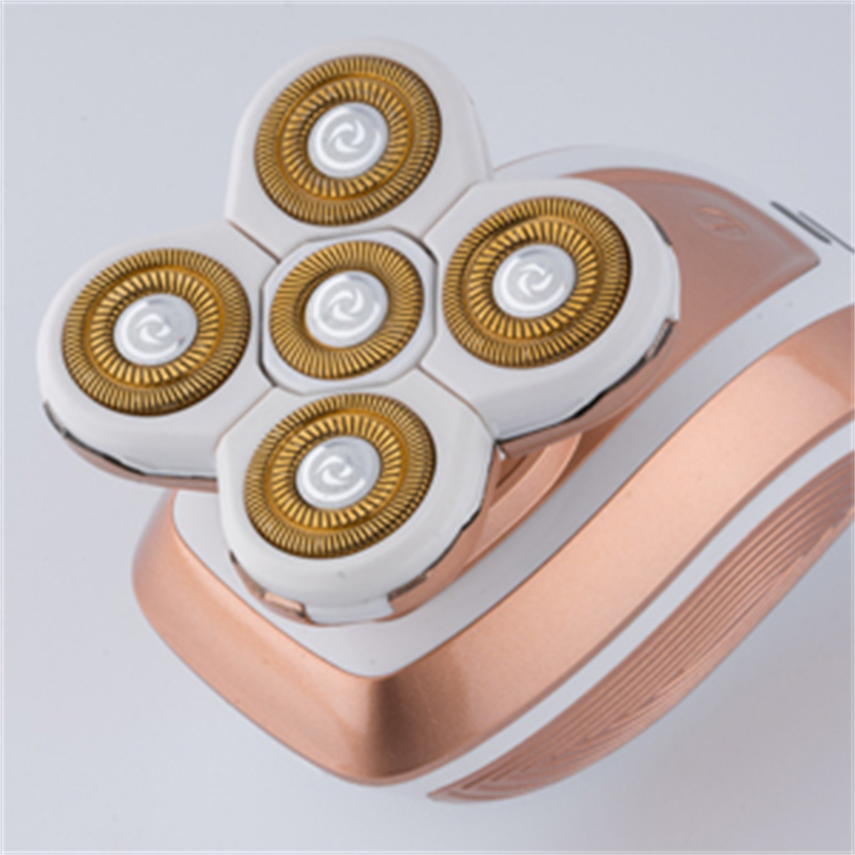 Nahaufnahme eines Damen-Elektro-Rasierers. Weißes und roségoldenes Farbschema.