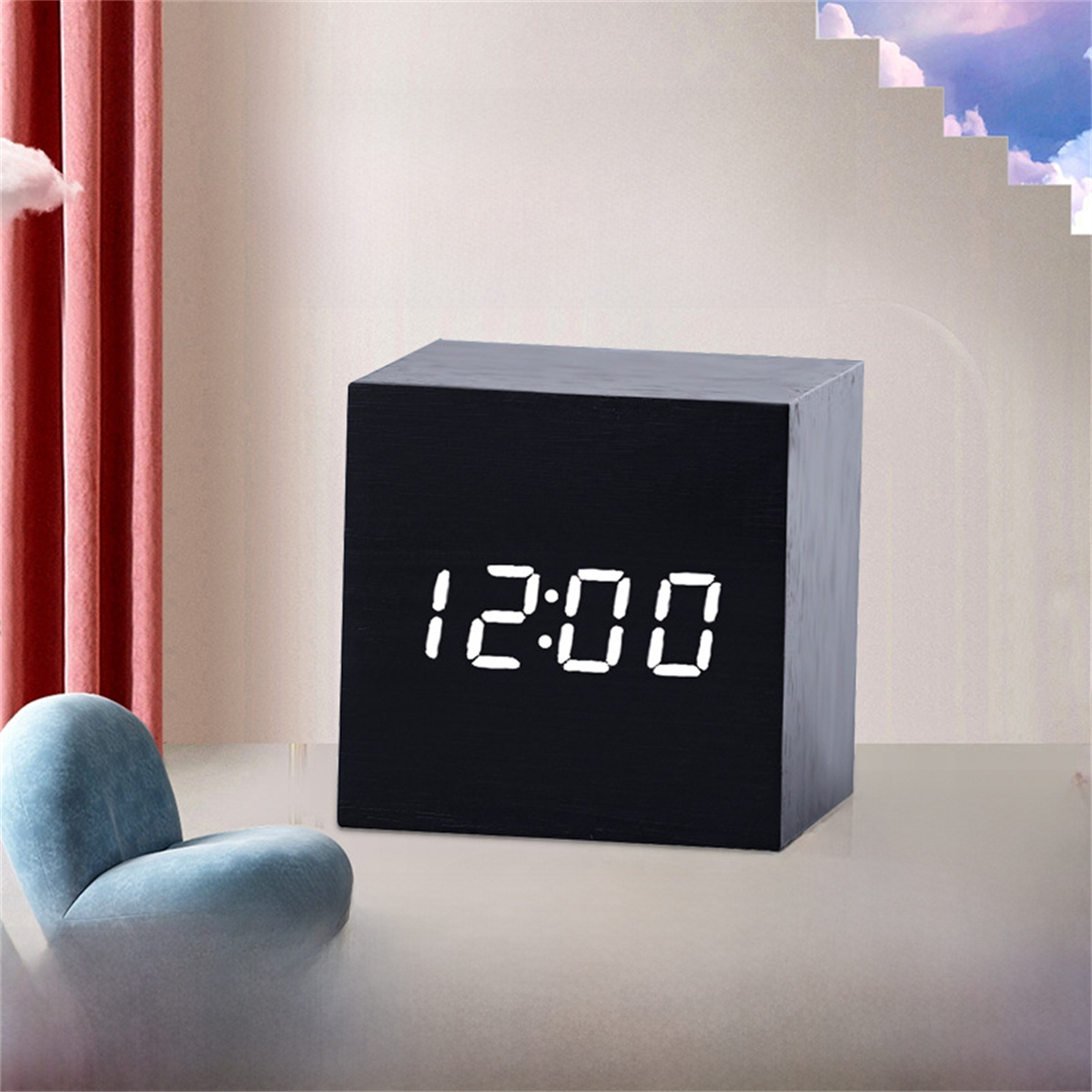 Schwarze Holzwürfeluhr, die 12:00 Uhr anzeigt, mit einem blauen Stuhl.