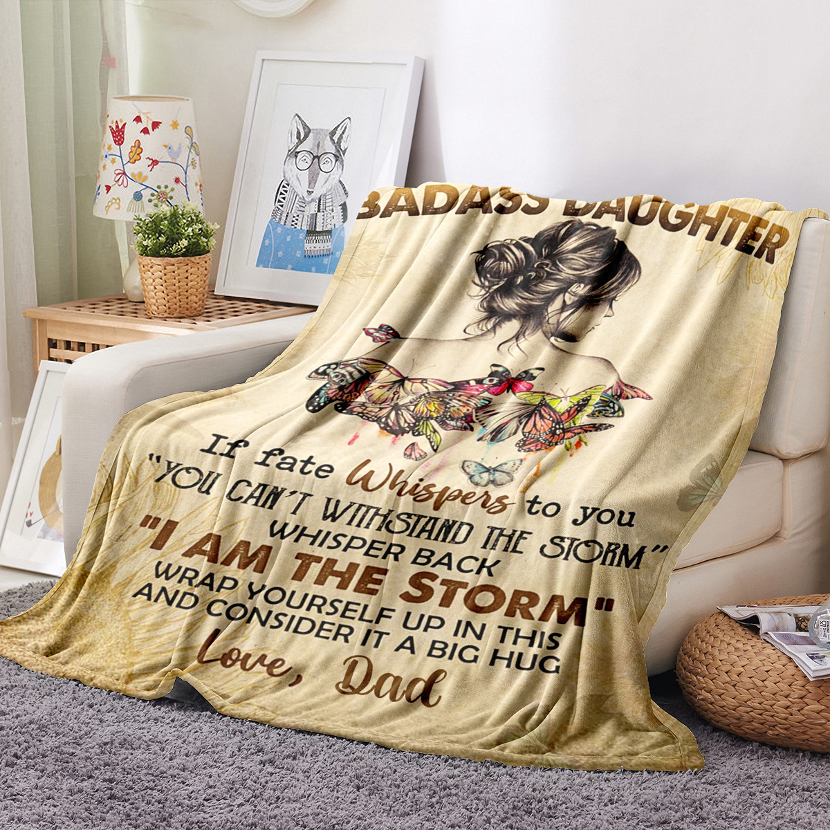 Decke auf Sofa mit Frauenillustration und Text. Gold- und Beigetöne.