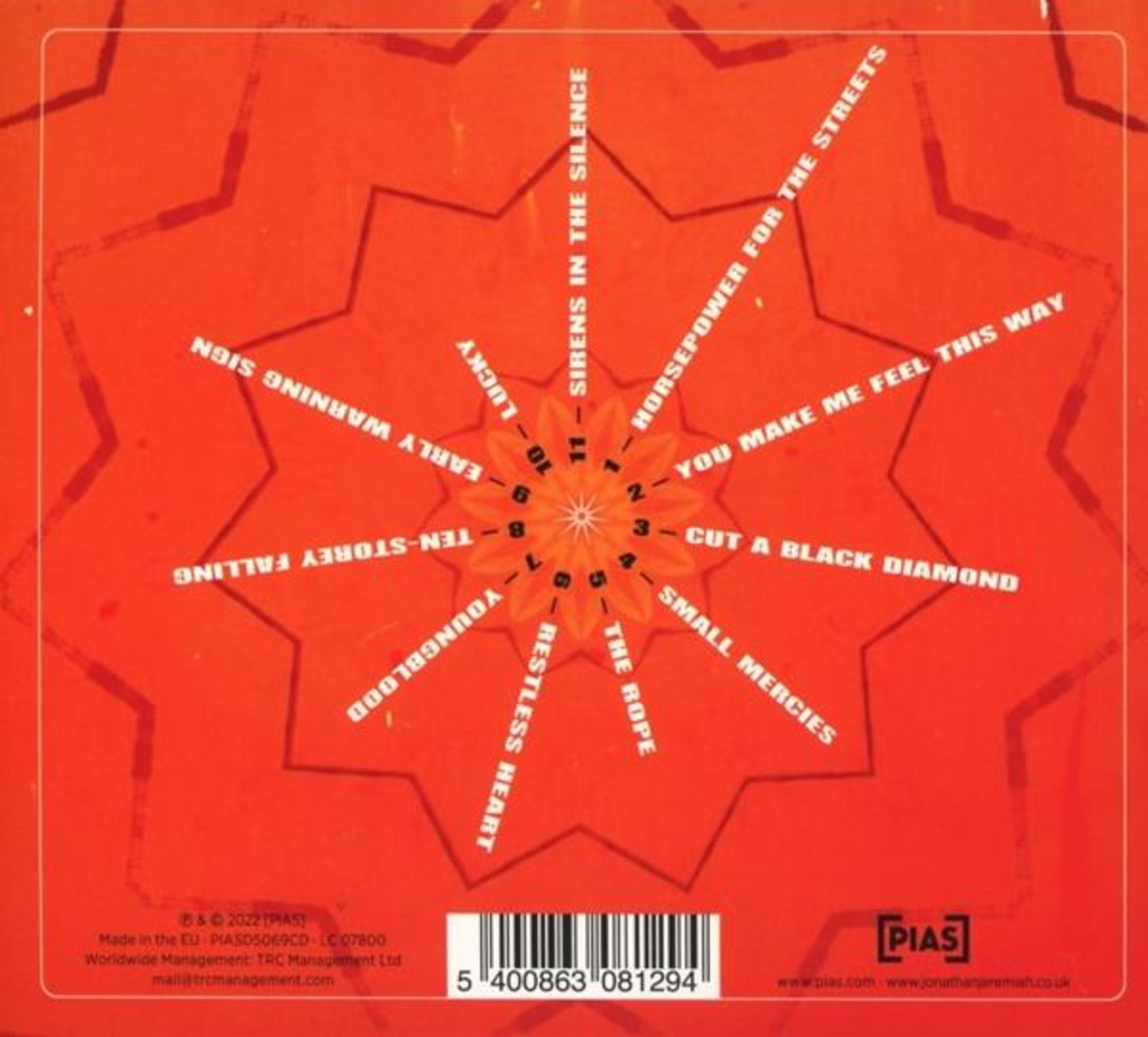 Copertina rossa con titoli di canzoni disposti in cerchio, come un quadrante di orologio.