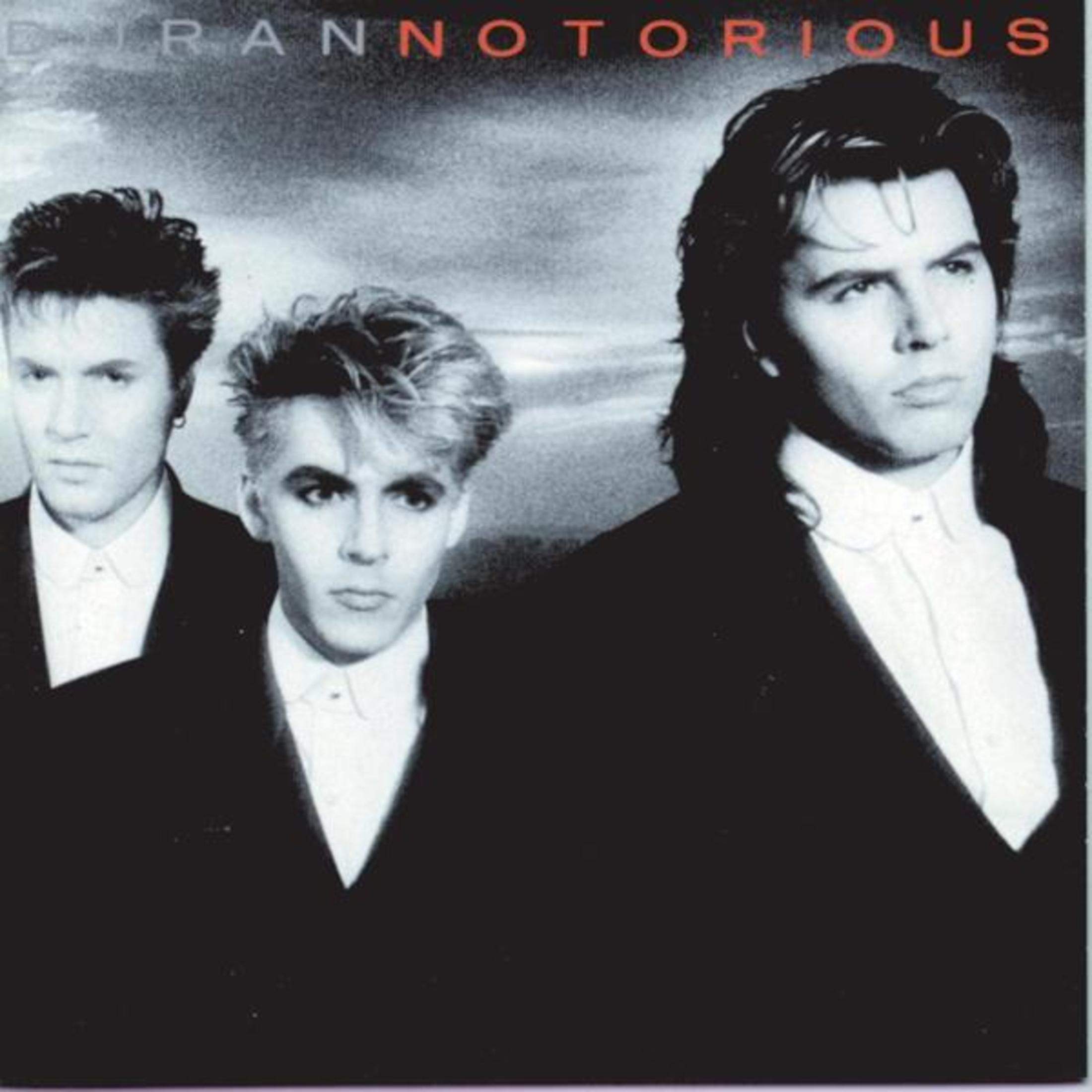 Pochette d'album : Membres du groupe Duran Duran, trois hommes en costume noir et chemise blanche, fond sombre.