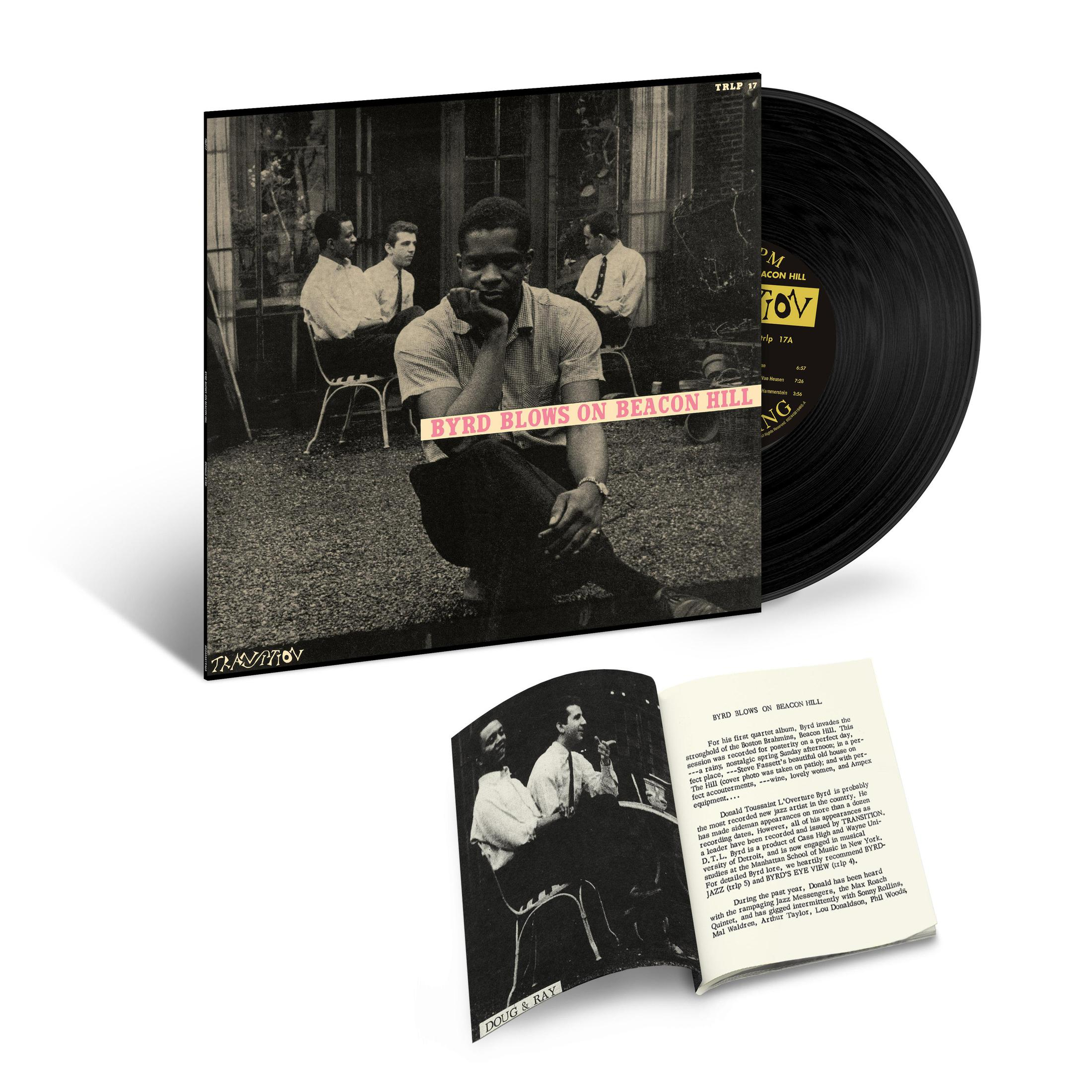 Copertina dell'album con un'immagine in bianco e nero di uomini. Vinile e libretto visibili.