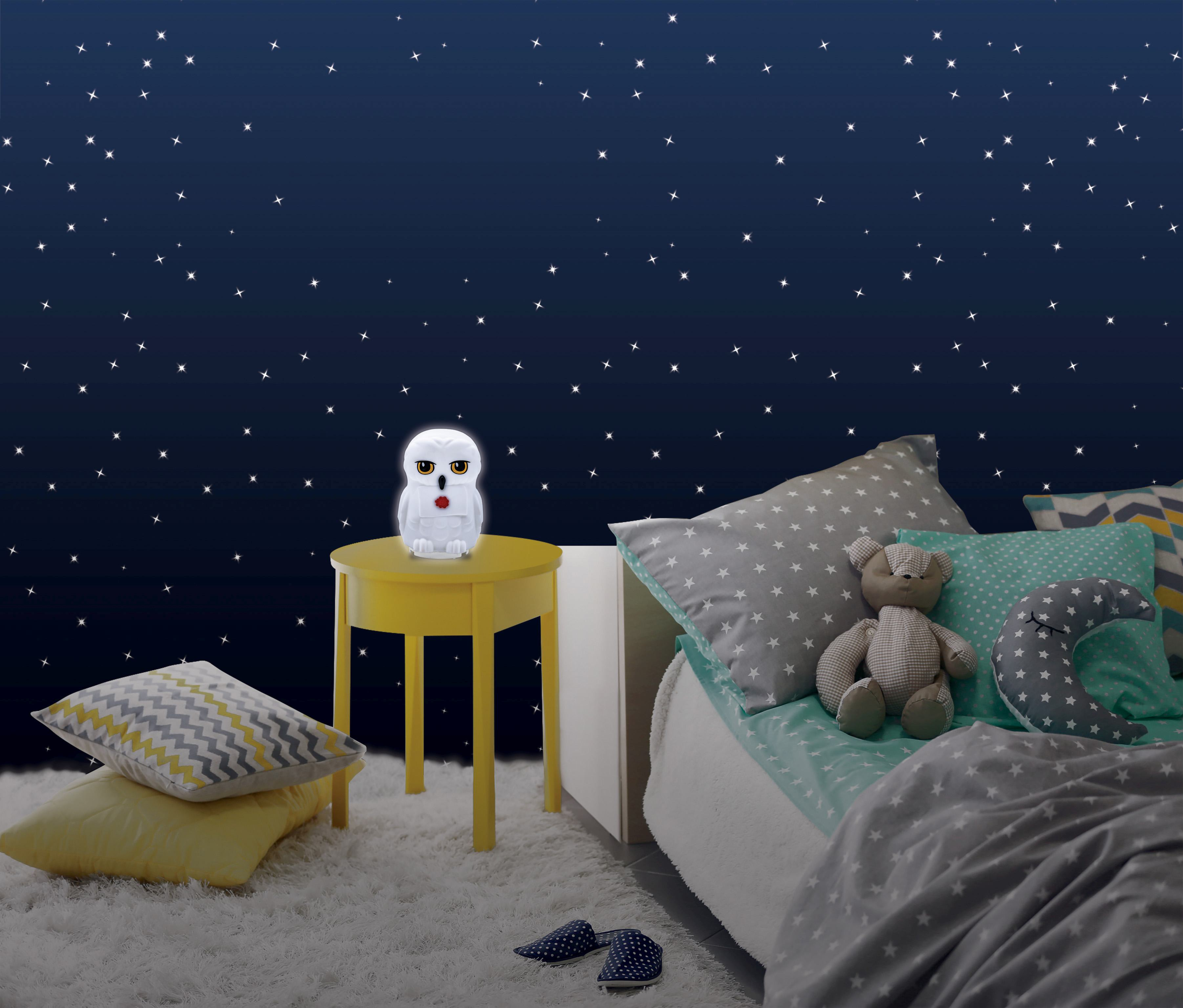 Luz nocturna con forma de búho en mesa amarilla, ambiente de dormitorio.