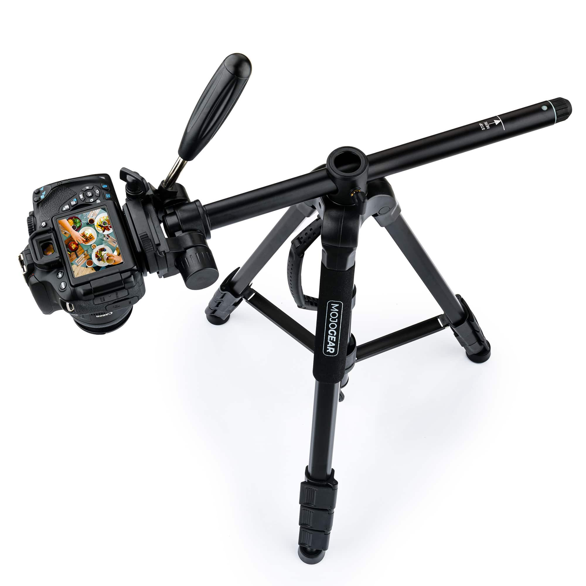Black camera on a black tripod, white background. Camera pointed to the left.