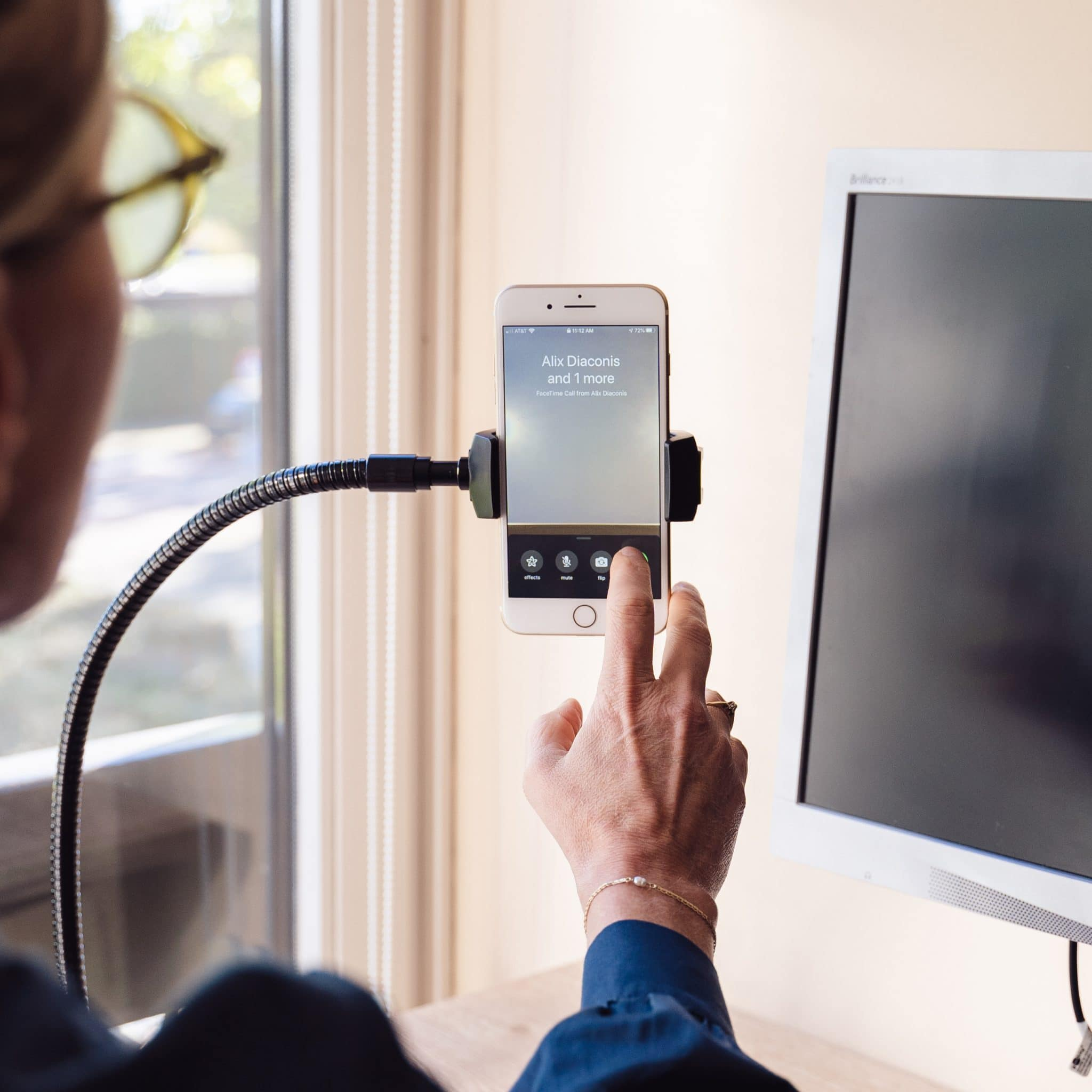 Een vrouw die een telefoon vasthoudt, deze gebruikt voor een video-oproep.