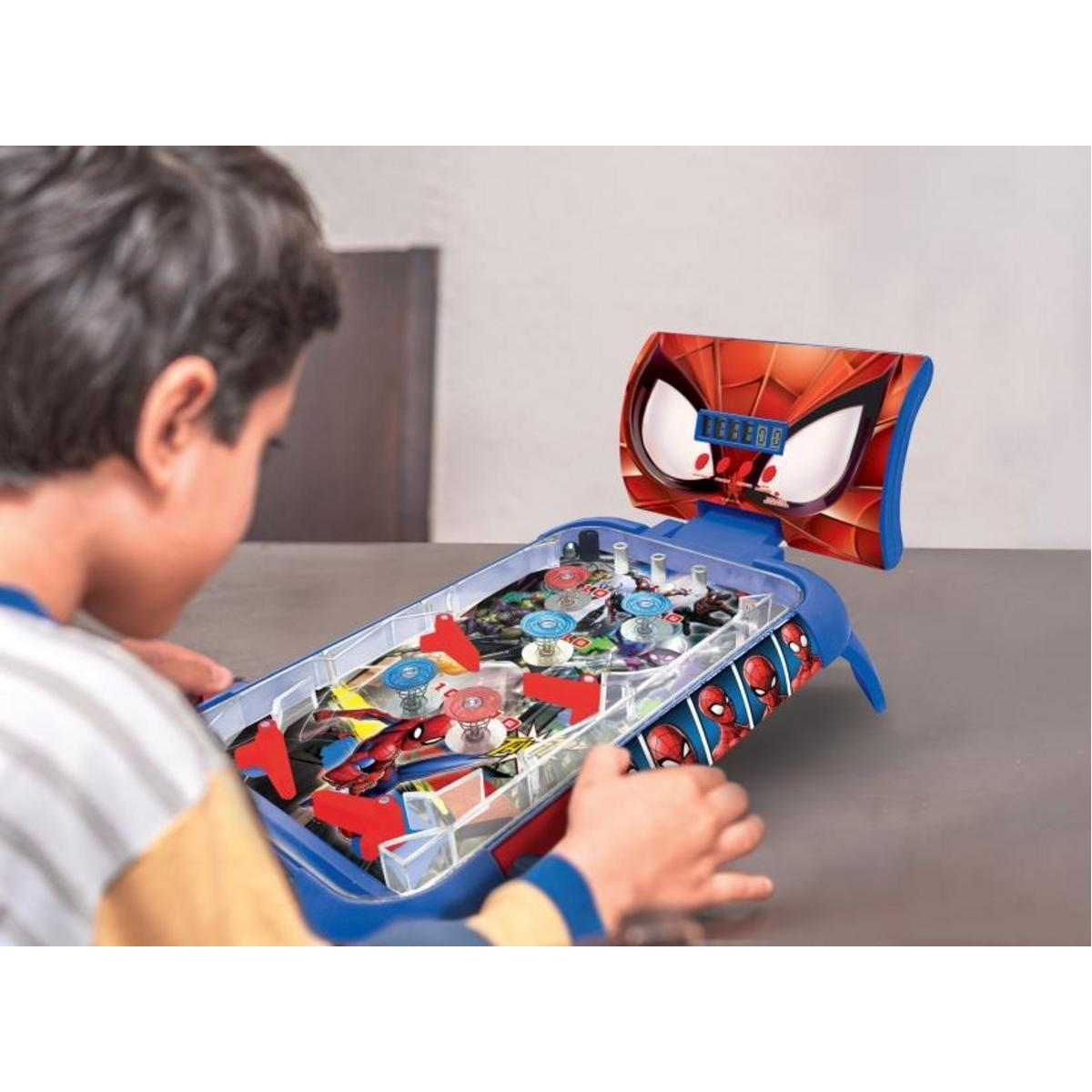 Ein Junge spielt einen Spider-Man-Flipperautomaten. Die Maschine ist blau und rot.