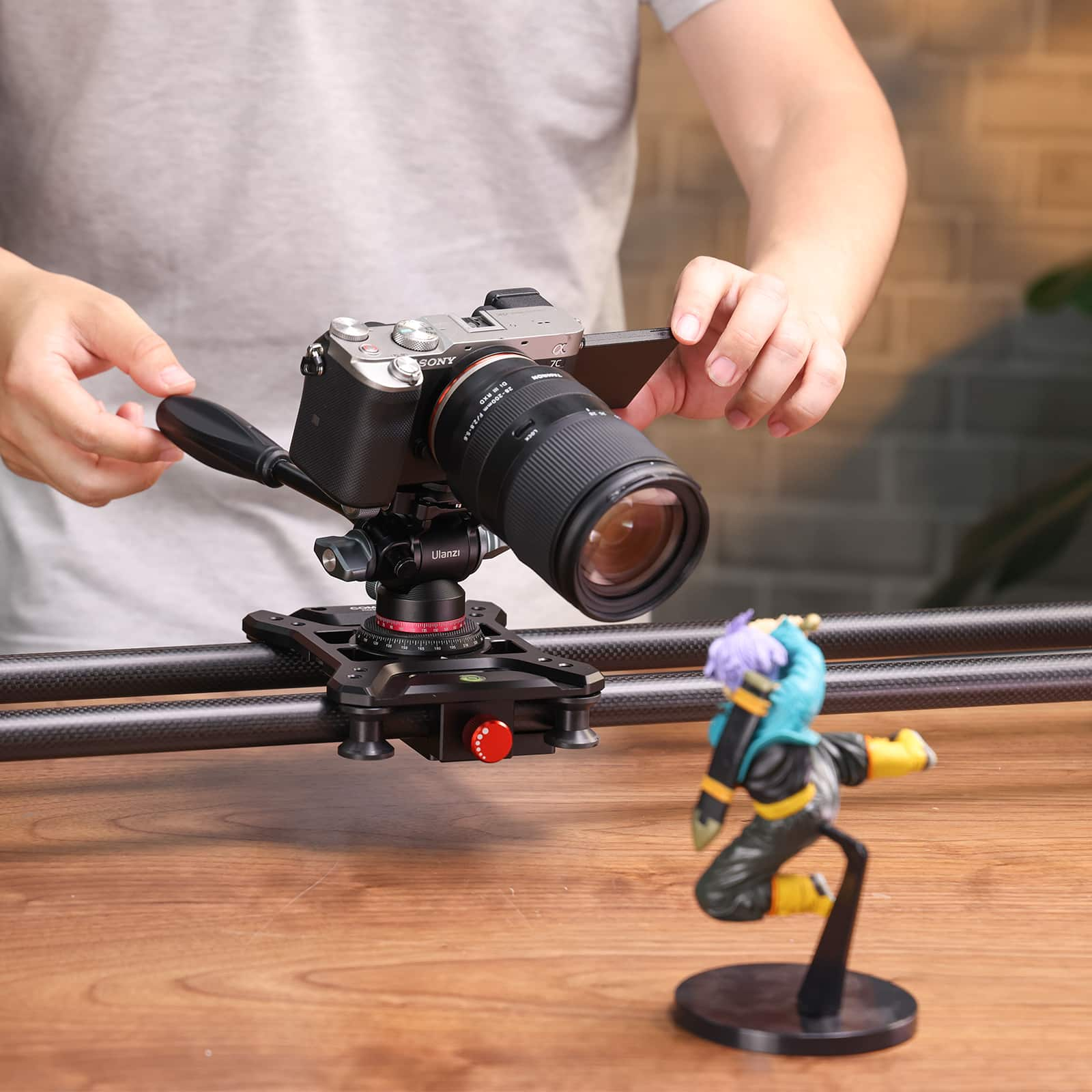 Kamera na suwaku obsługiwana przez osobę. Mała figurka po prawej stronie.