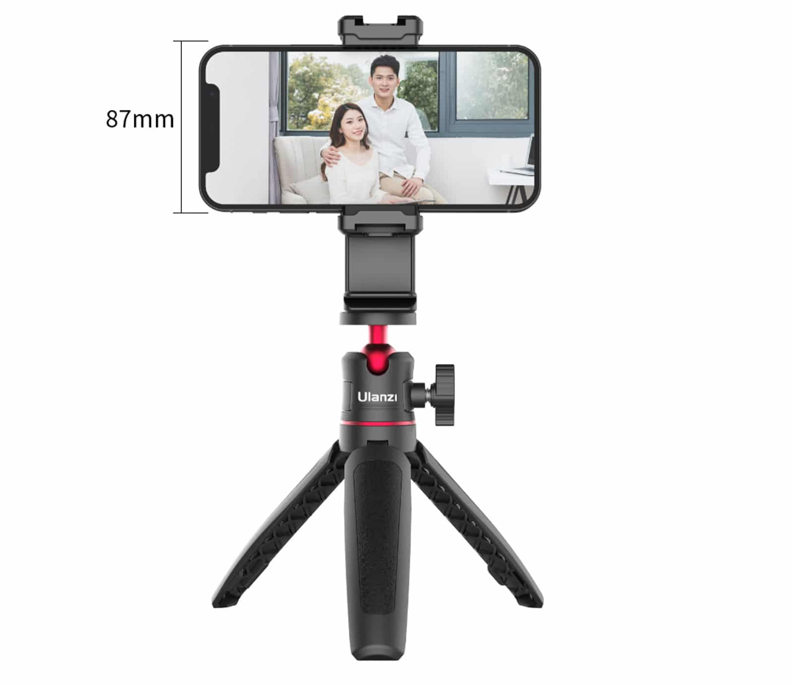 Smartphone sur un trépied, affichant une photo de couple. Trépied noir et rouge. Fond blanc.
