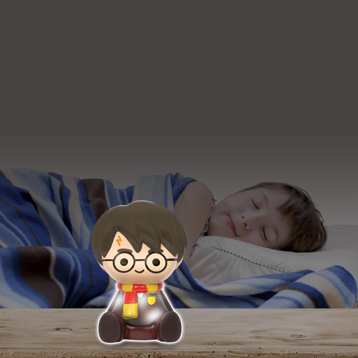 Eine Harry Potter Lampe mit einem schlafenden Jungen im Hintergrund.