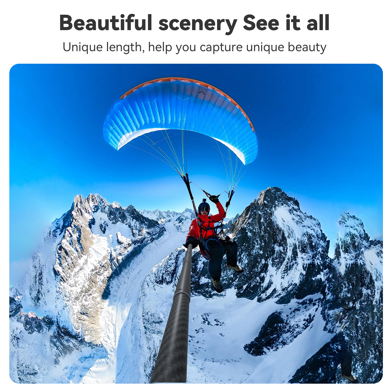 Een persoon die paraglidet over besneeuwde bergen onder een blauwe hemel met een groothoekperspectief.