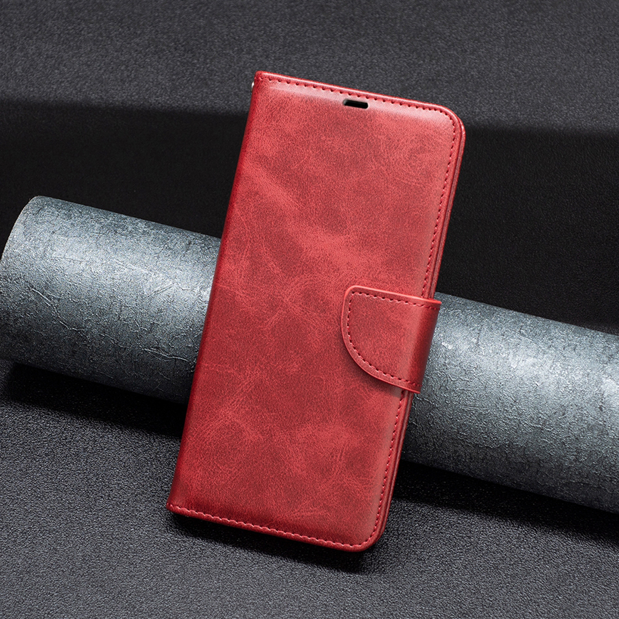 Étui de téléphone en cuir rouge, fermé par un rabat. Fermeture à bouton visible à droite.