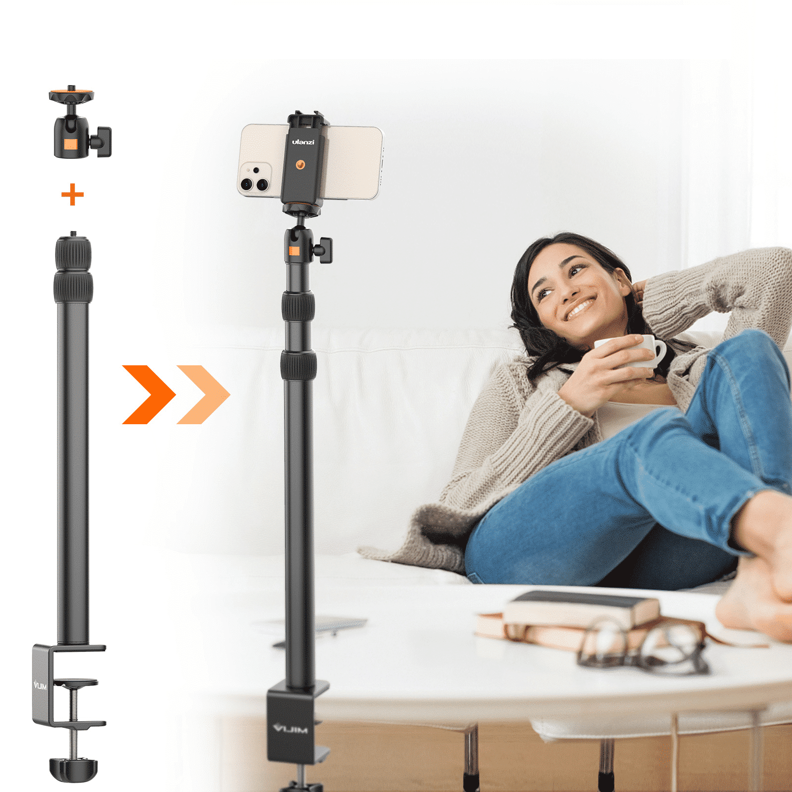 Kobieta siedzi na białej kanapie, używając uchwytu na telefon z telefonem. Z przodu stół z książkami.