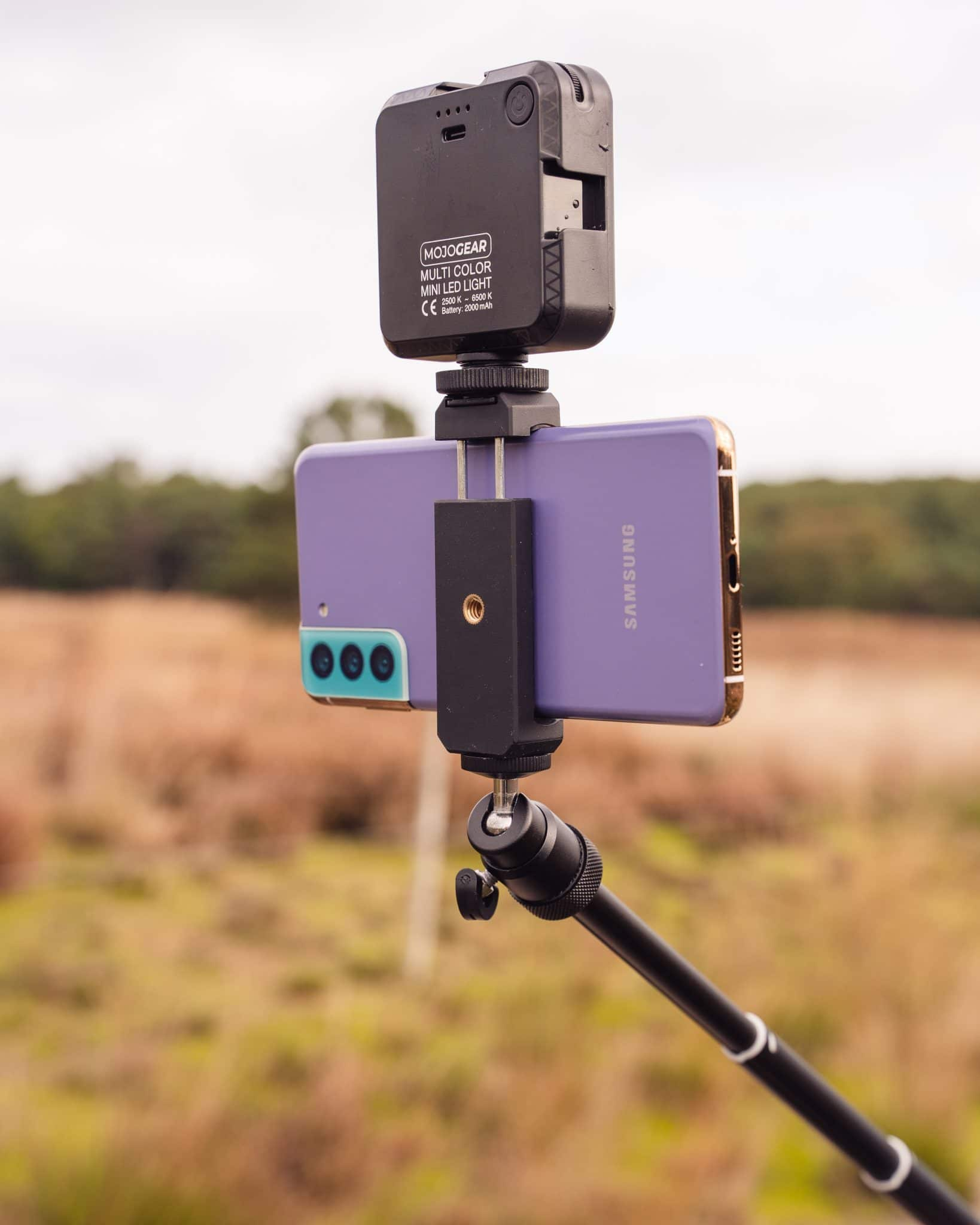 Ein Telefon auf einem Stativ mit einer kleinen Leuchte in einem Feld mit Pflanzen.