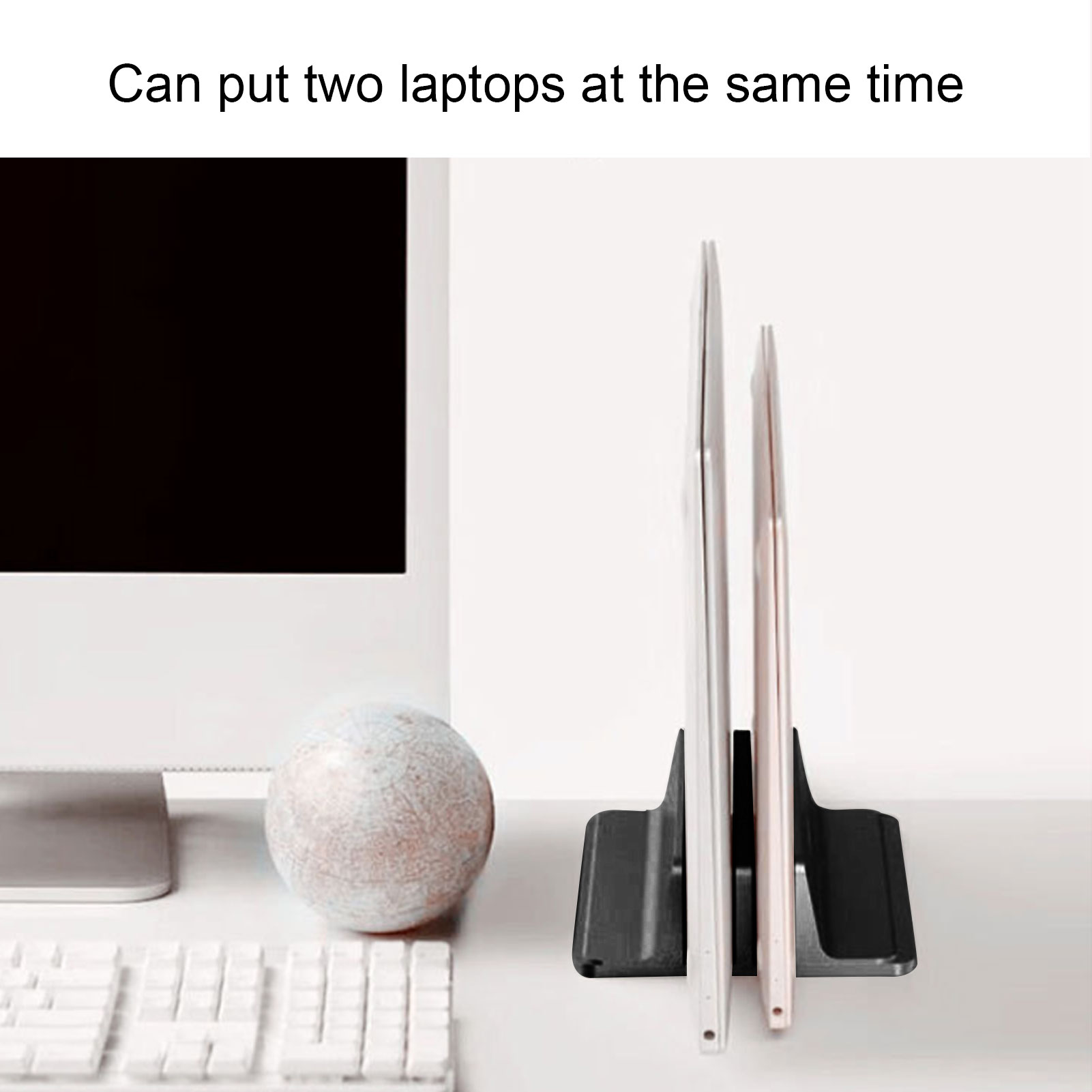 Zwei Laptops stehen vertikal in einem schwarzen Ständer auf einem weißen Schreibtisch.