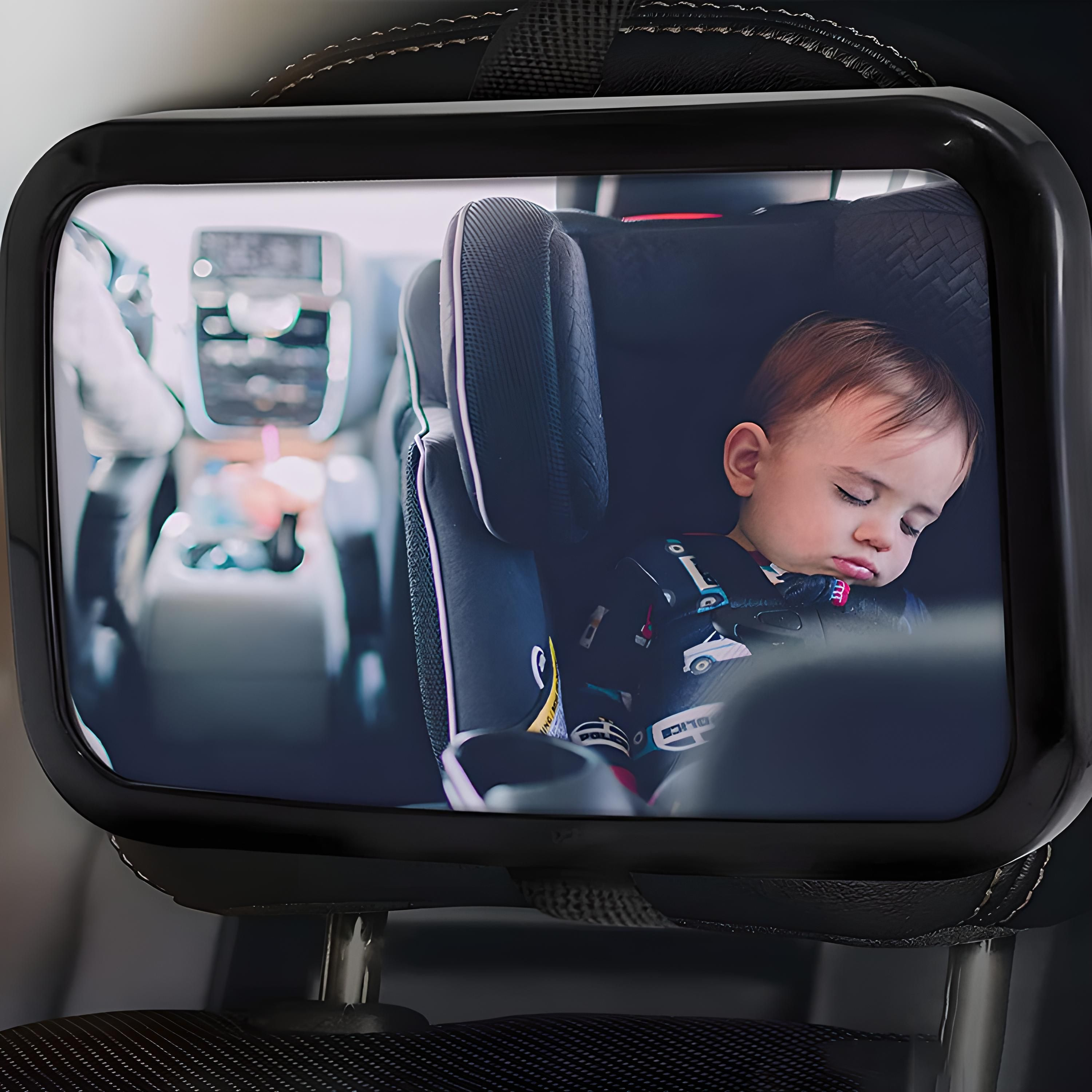 Rückspiegel für den Autositz. Baby im Sitz, schlafend. Schwarzer Rahmen. Spiegel reflektiert Baby und Innenraum.