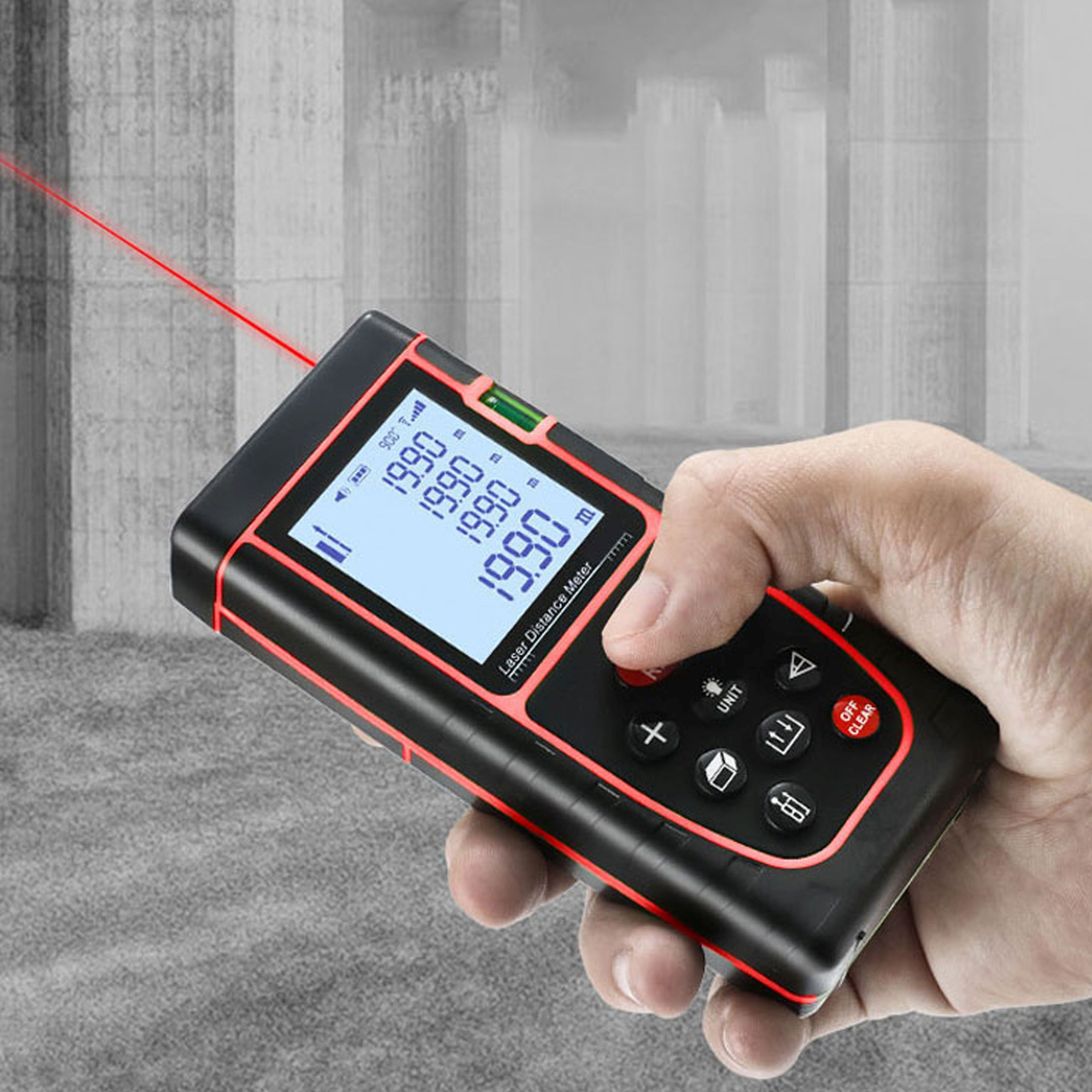 Eine Person hält ein Laser-Entfernungsmessgerät. Das Messgerät zeigt Messwerte auf einem Bildschirm mit rotem Laserpunkt an.