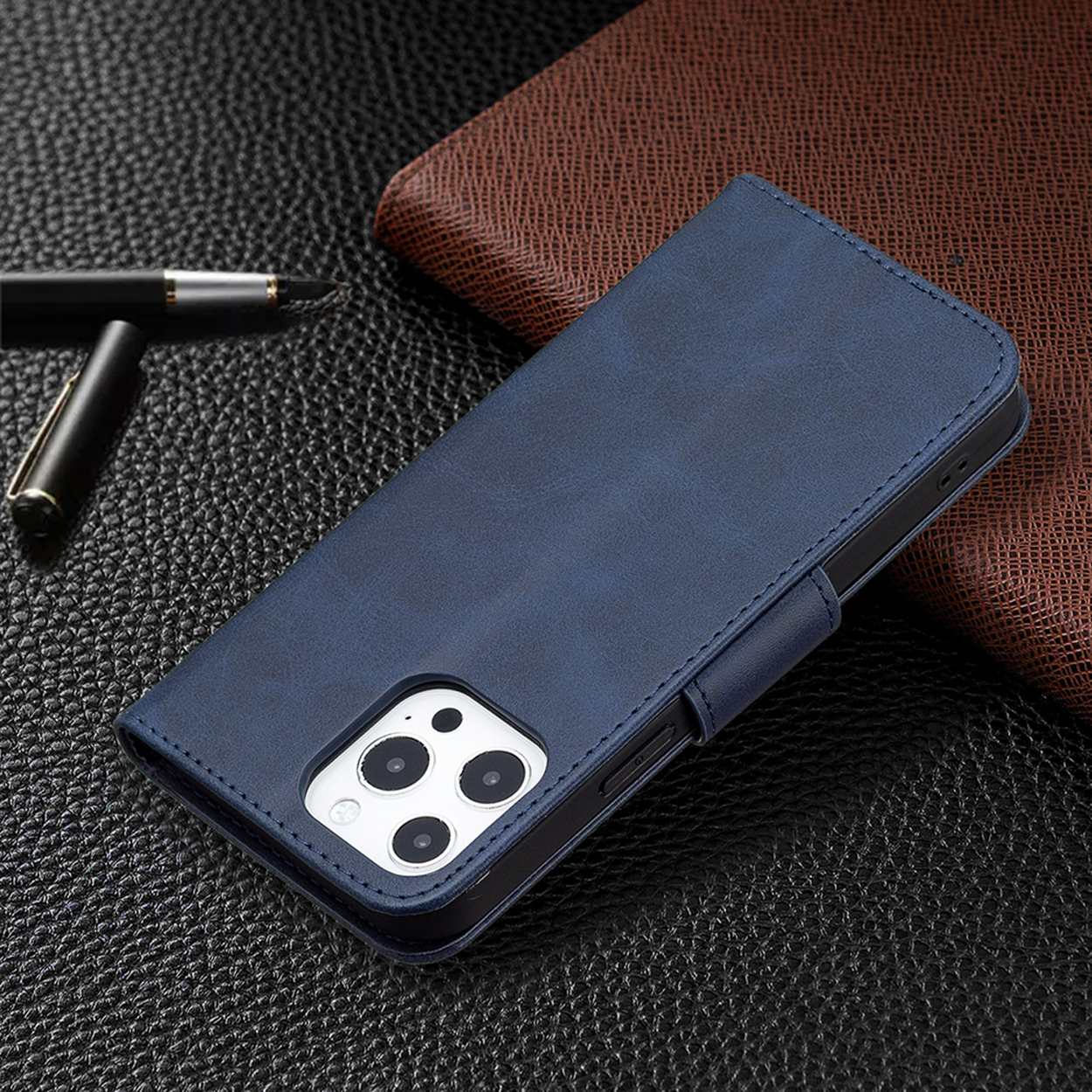 Een blauwe leren telefoonhoes met een telefoon erin, op een zwart gestructureerd oppervlak met een pen.