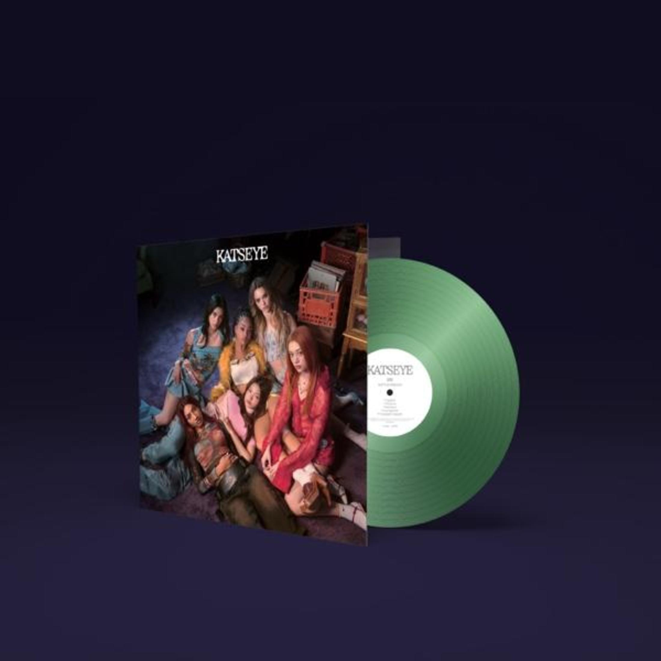 Copertina dell'album con un gruppo di donne sedute insieme, un disco in vinile verde, su sfondo blu scuro.