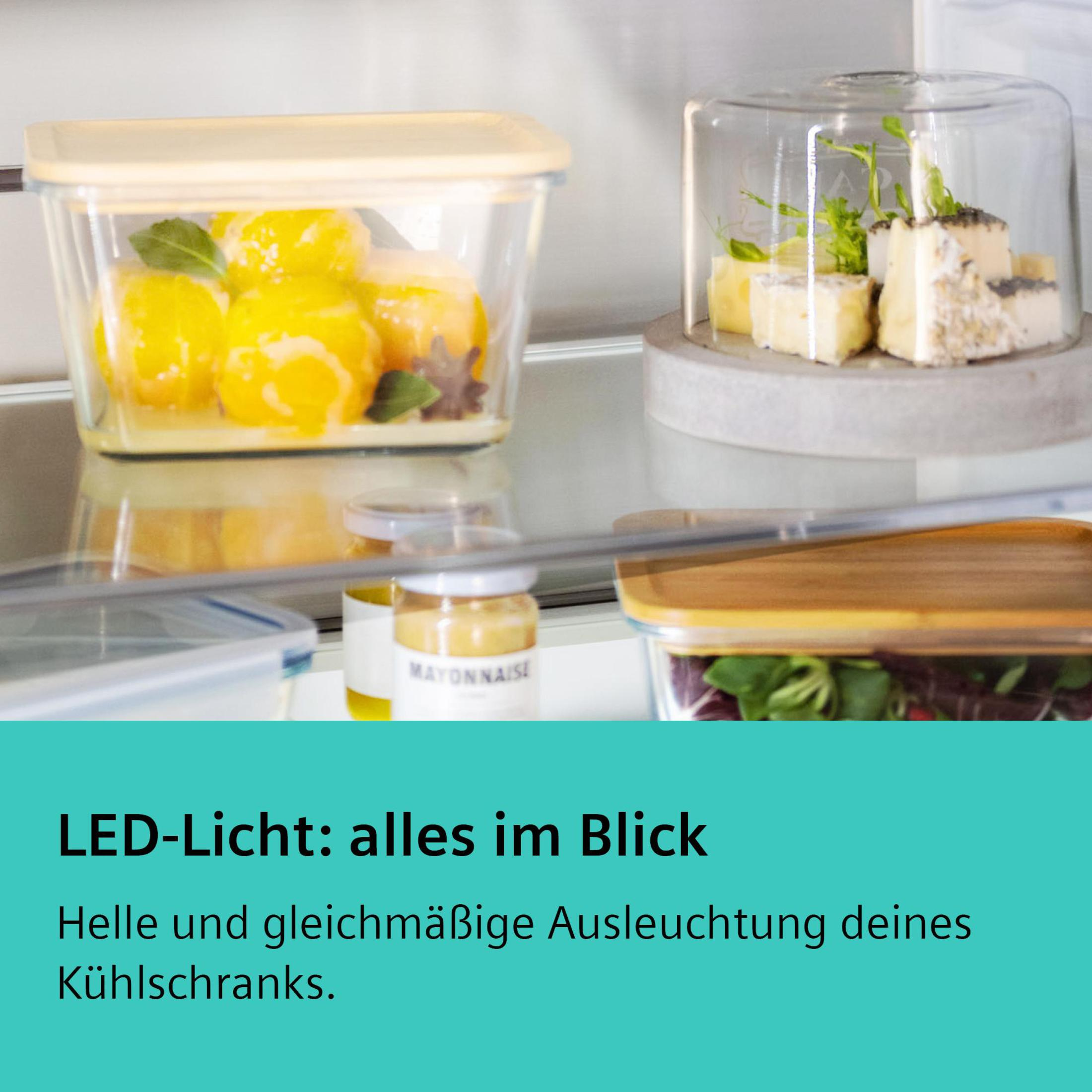 Kühlschrankinnenraum mit sichtbaren Lebensmitteln, darunter Käse und Zitronen.