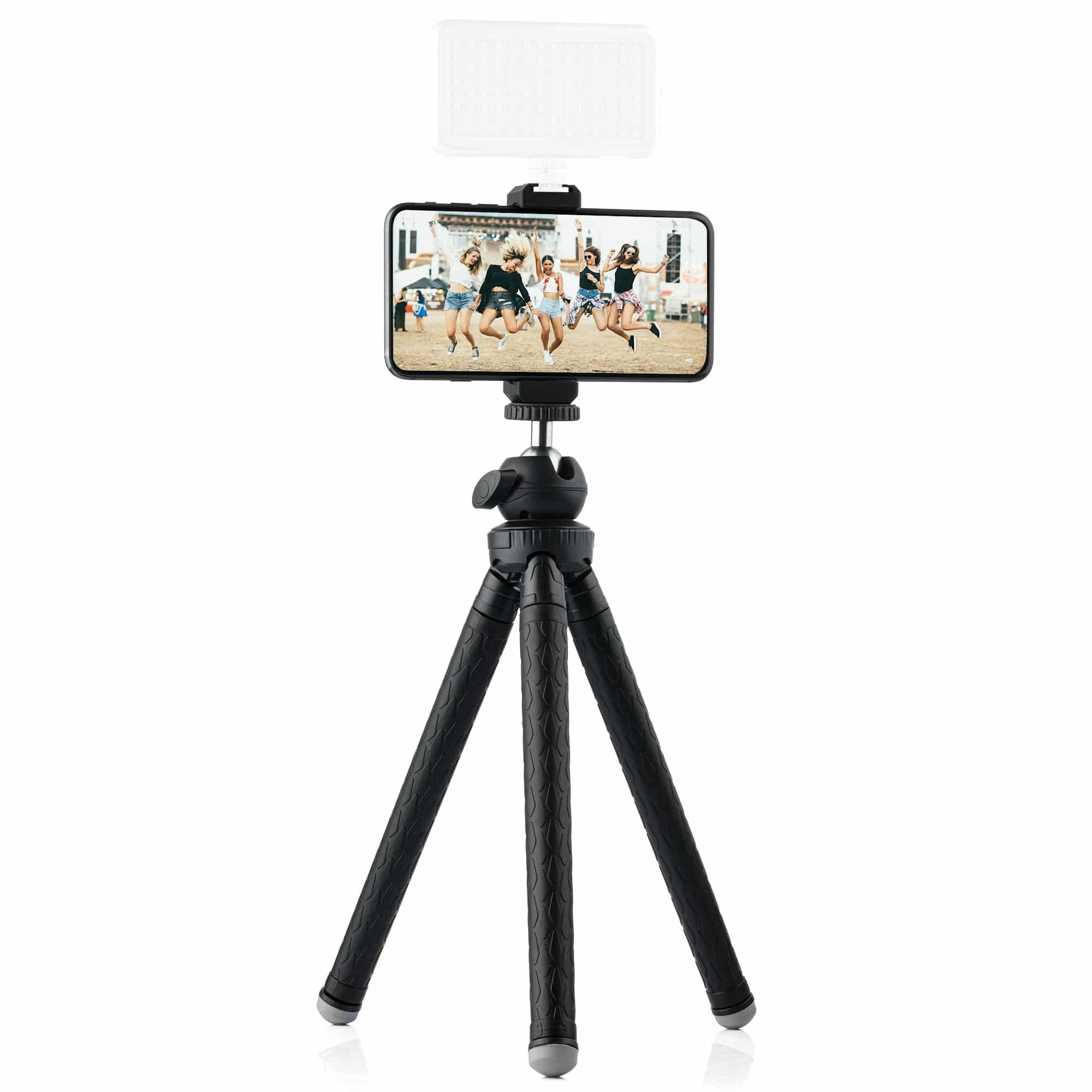 A smartphone on a tripod is displaying a photo of people jumping. A small light is above the phone.
