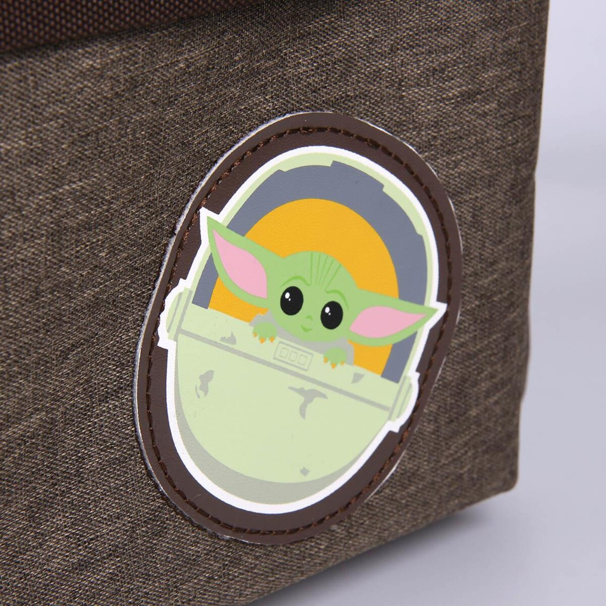 Un contenedor de tela marrón con una pegatina de Grogu (Baby Yoda) encima.