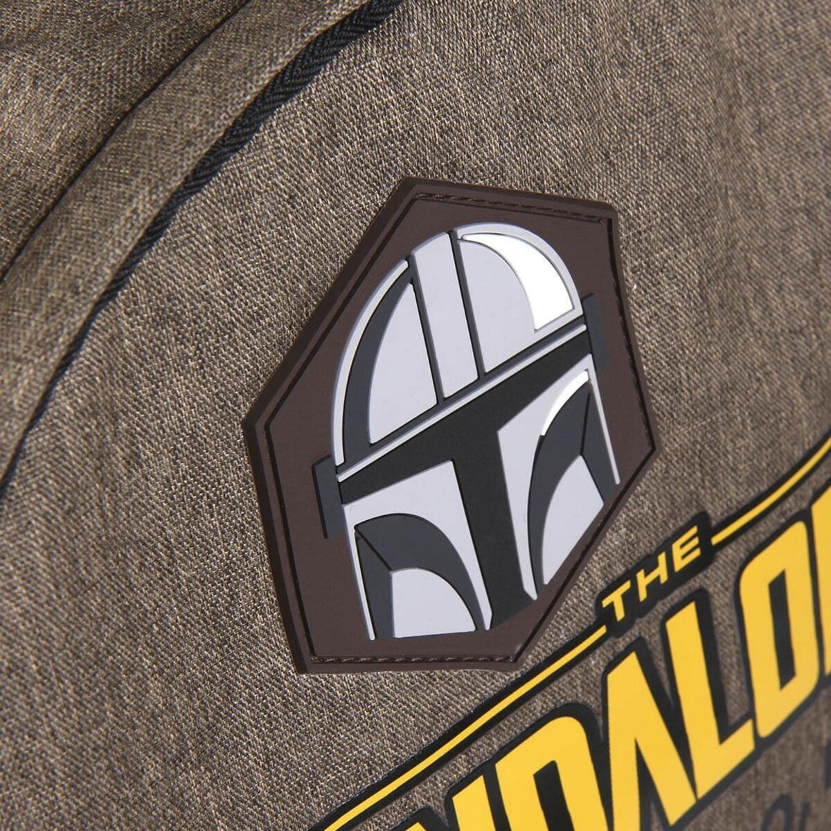 Primer plano de un parche de mochila, con el logotipo del casco mandaloriano y las palabras 'THE MANDALORIAN'.