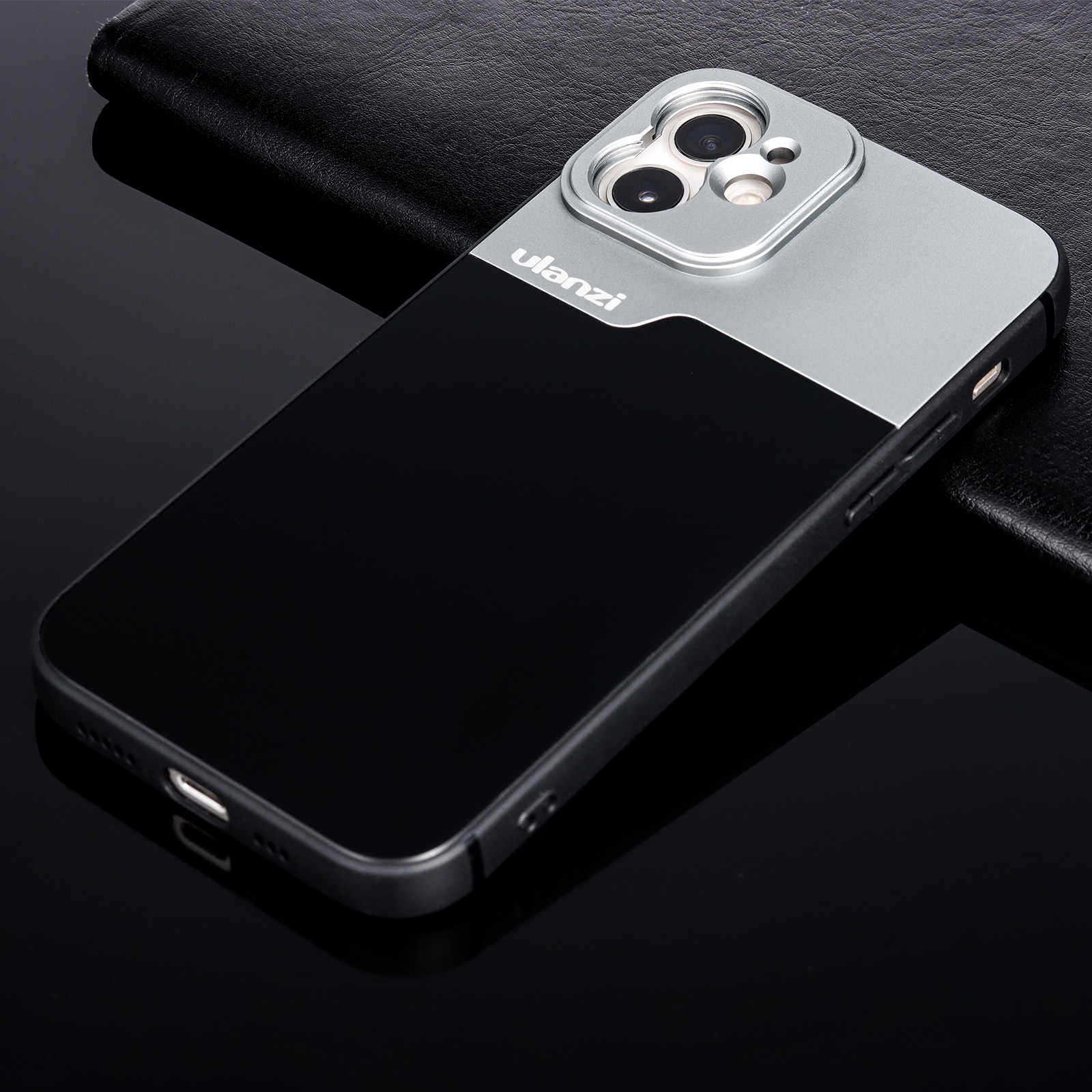 Close-up of a black and silver phone case on a black surface.