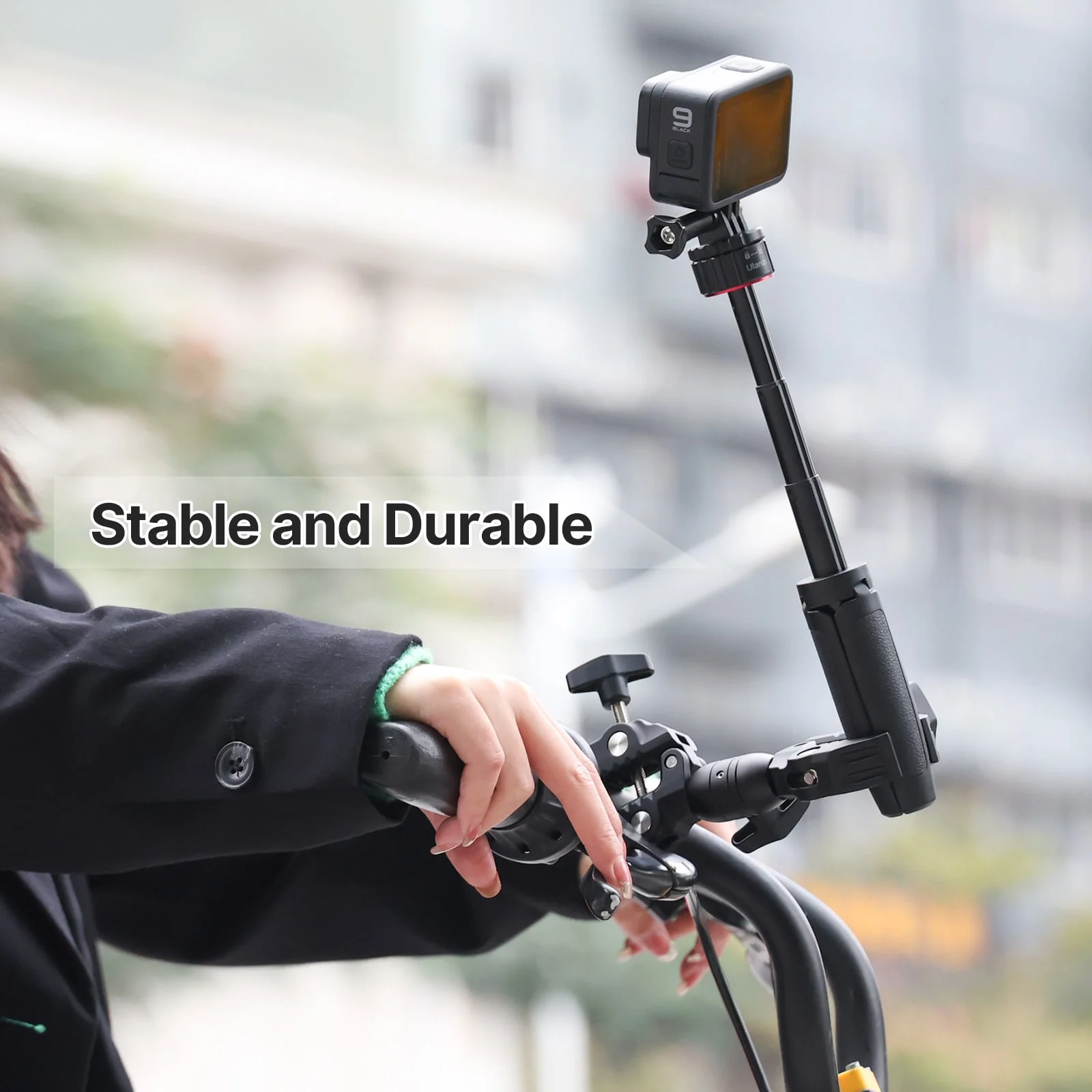Una persona che tiene una fotocamera GoPro sul manubrio di una bici con il testo "Stabile e durevole".
