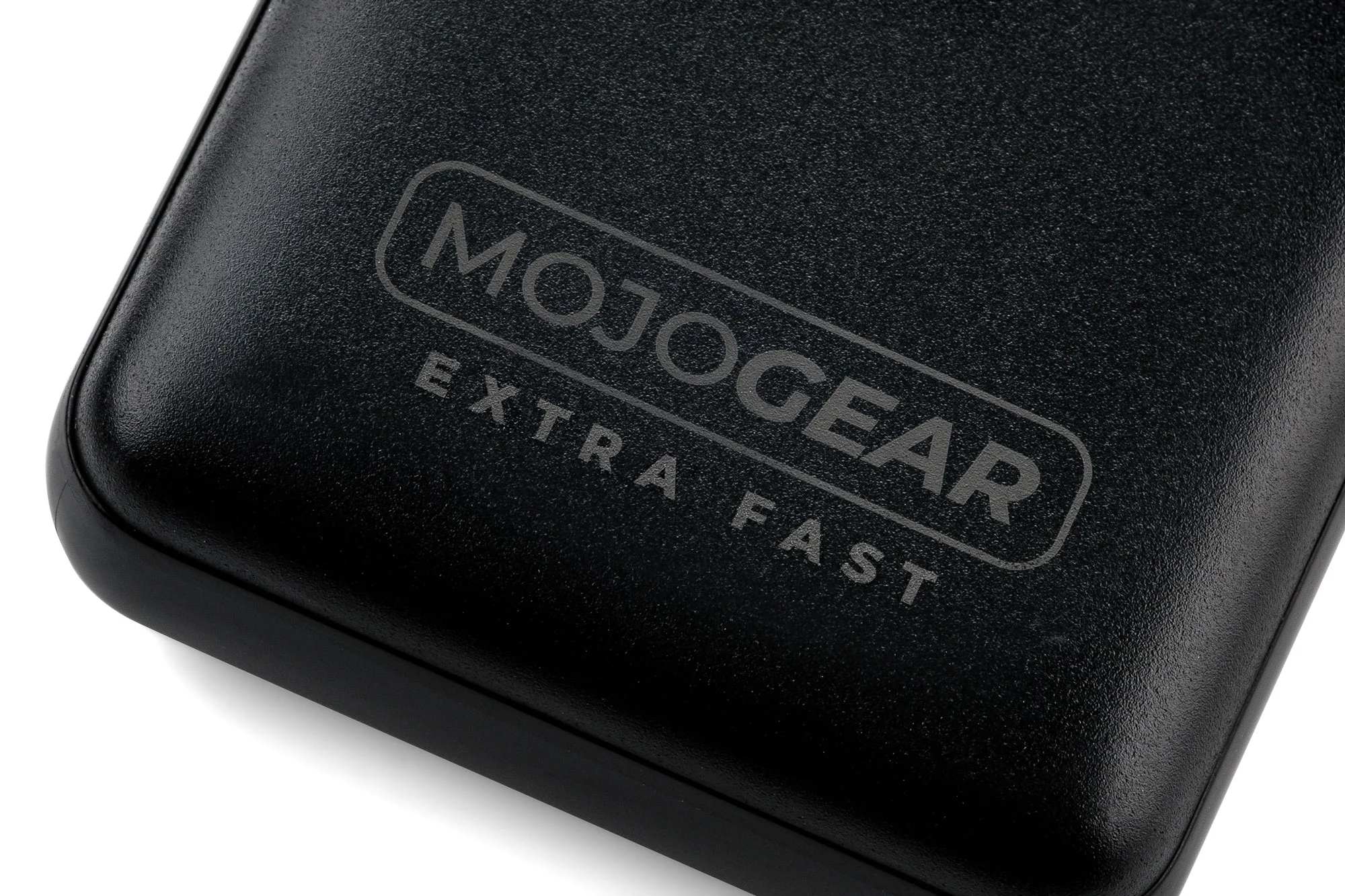 Batterie externe noire avec texte MOJOGEAR EXTRA FAST. L'appareil est vu d'un angle.