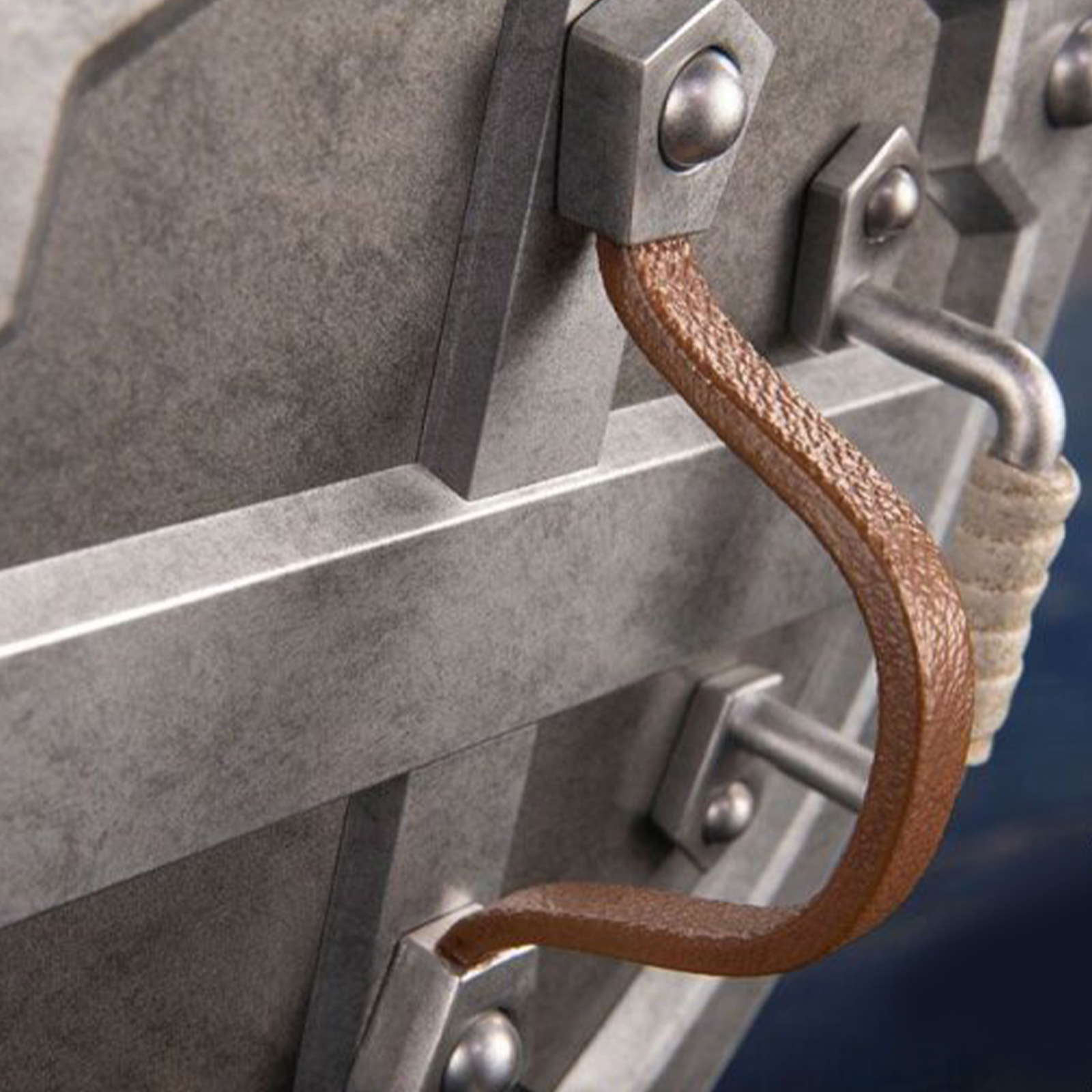 Nahaufnahme eines Metallschildgriffs. Brauner Lederriemen und Metallnieten.