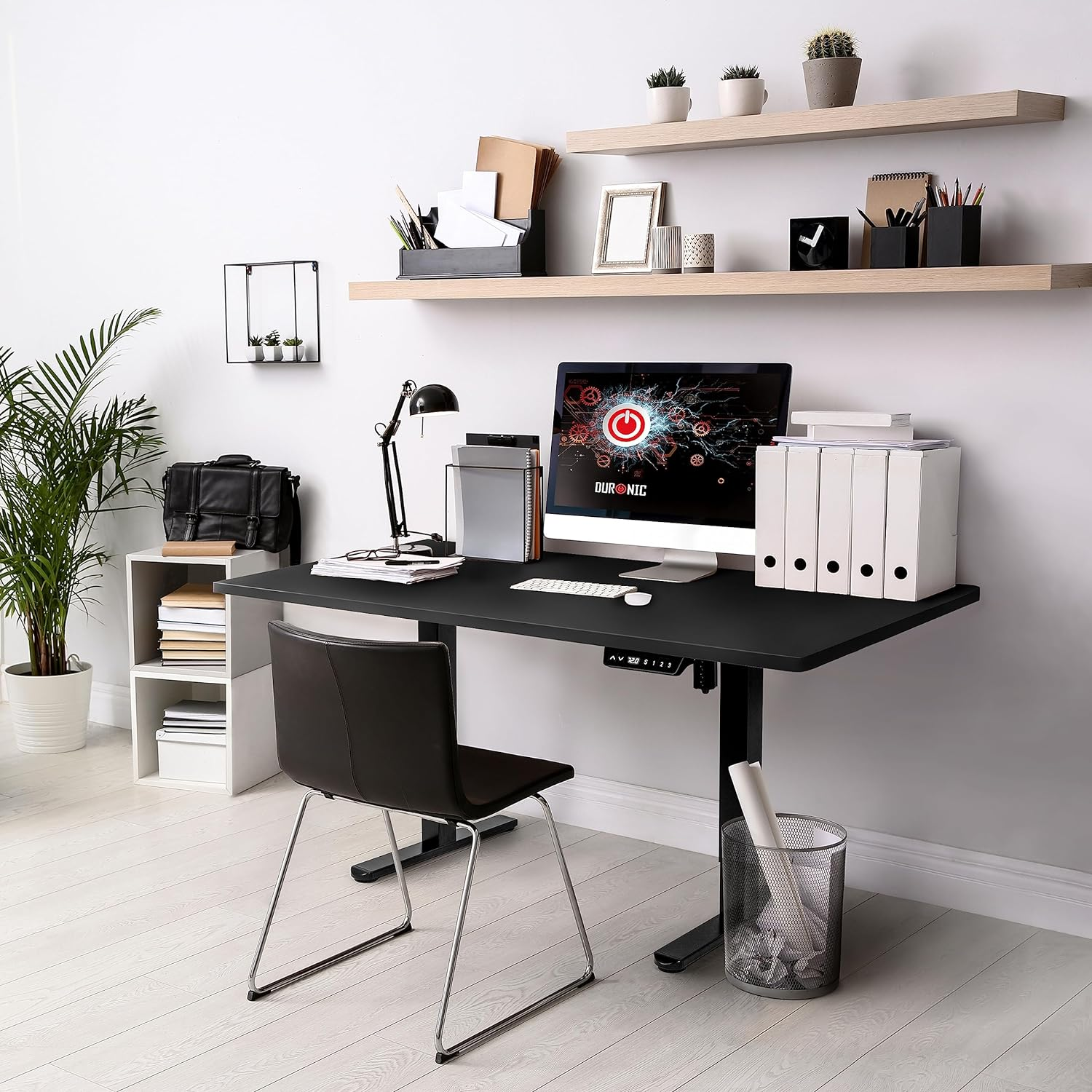 Modernes Heimbüro mit schwarzem Schreibtisch, Computer und Stuhl.