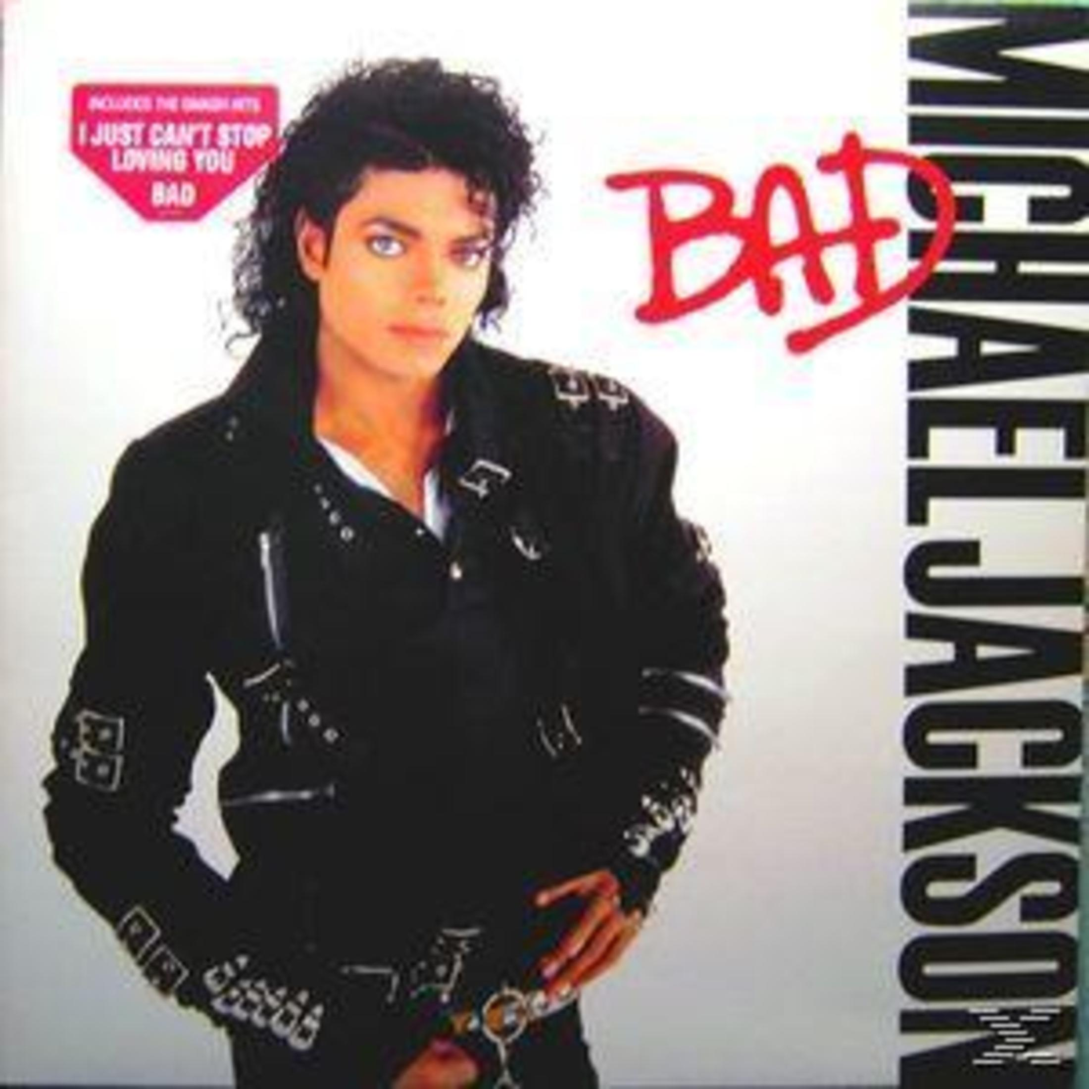 Albumhoes: Michael Jackson in een zwarte jas, met het woord BAD in rood boven zijn hoofd.