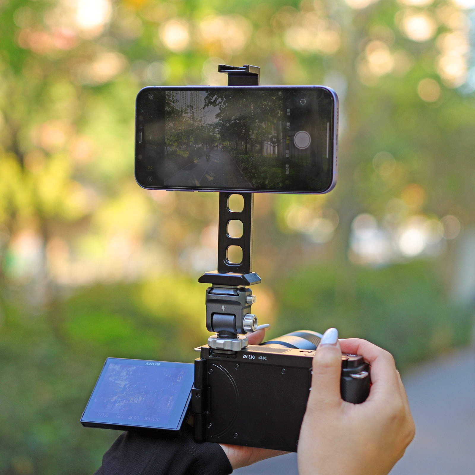 A phone is mounted on a camera, the screen shows a path. Hands hold the camera.