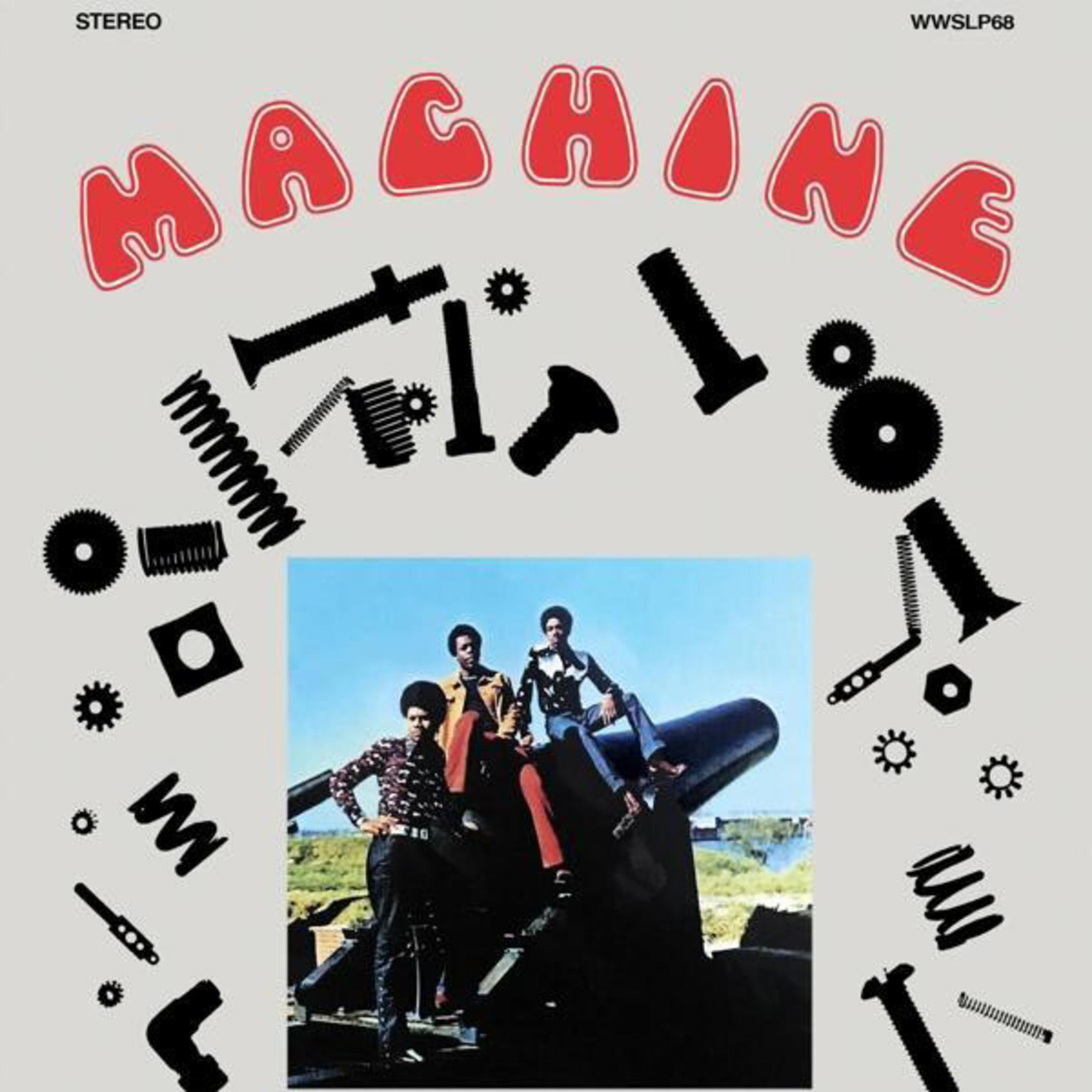Copertina dell'album che mostra parti di macchine e tre uomini neri su un cannone. Testo "MACHINE" in rosso.