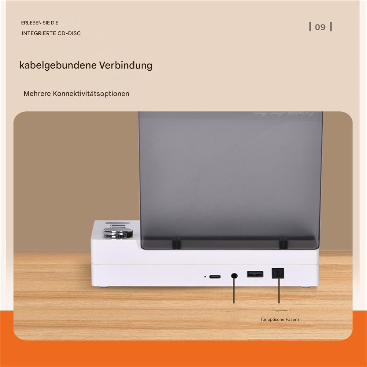 Weißes Gerät mit schwarzem Bildschirm, Anschlüssen und Text. Es steht auf Holz.