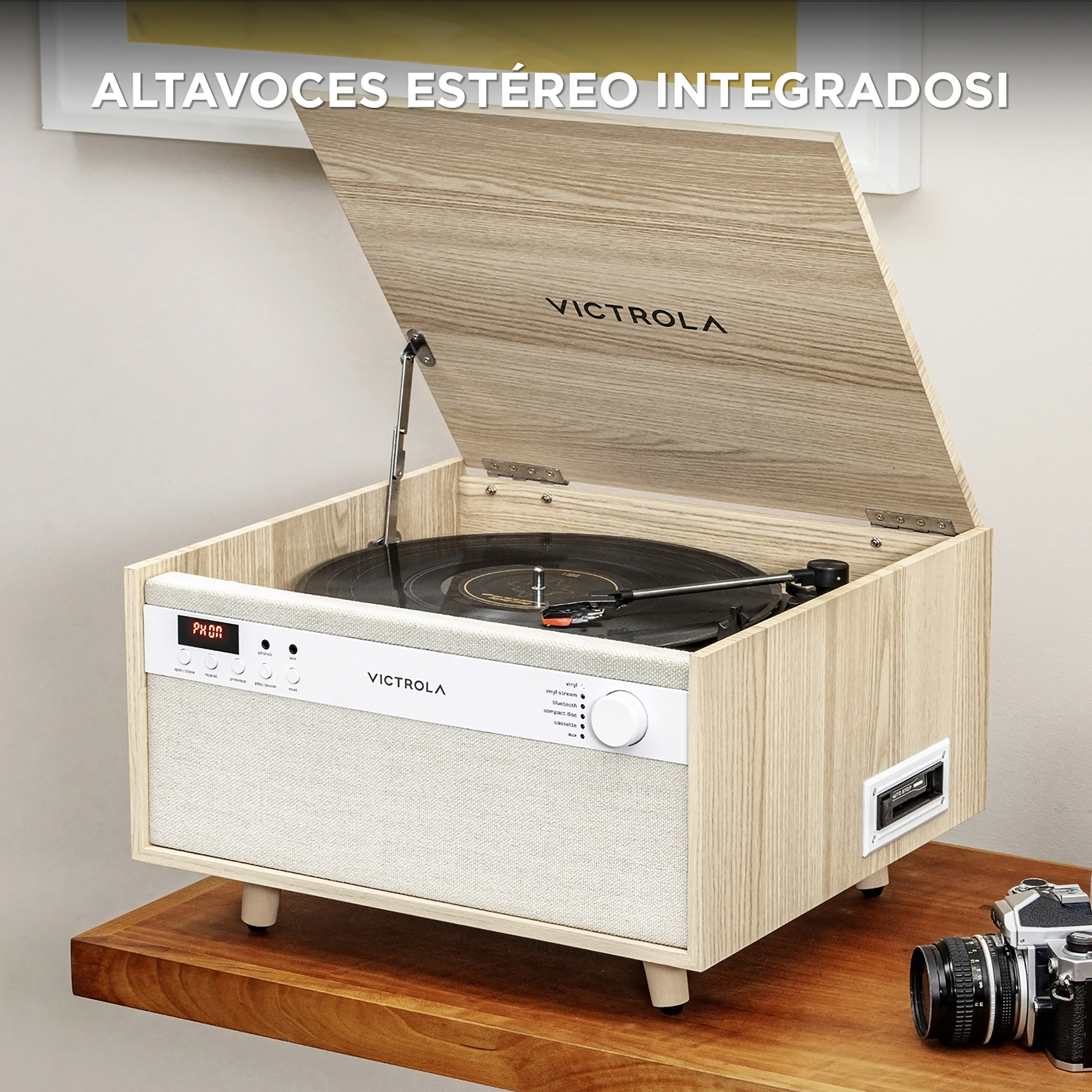 Giradischi Victrola vintage in legno con coperchio aperto, un disco e controlli. Una fotocamera a lato.
