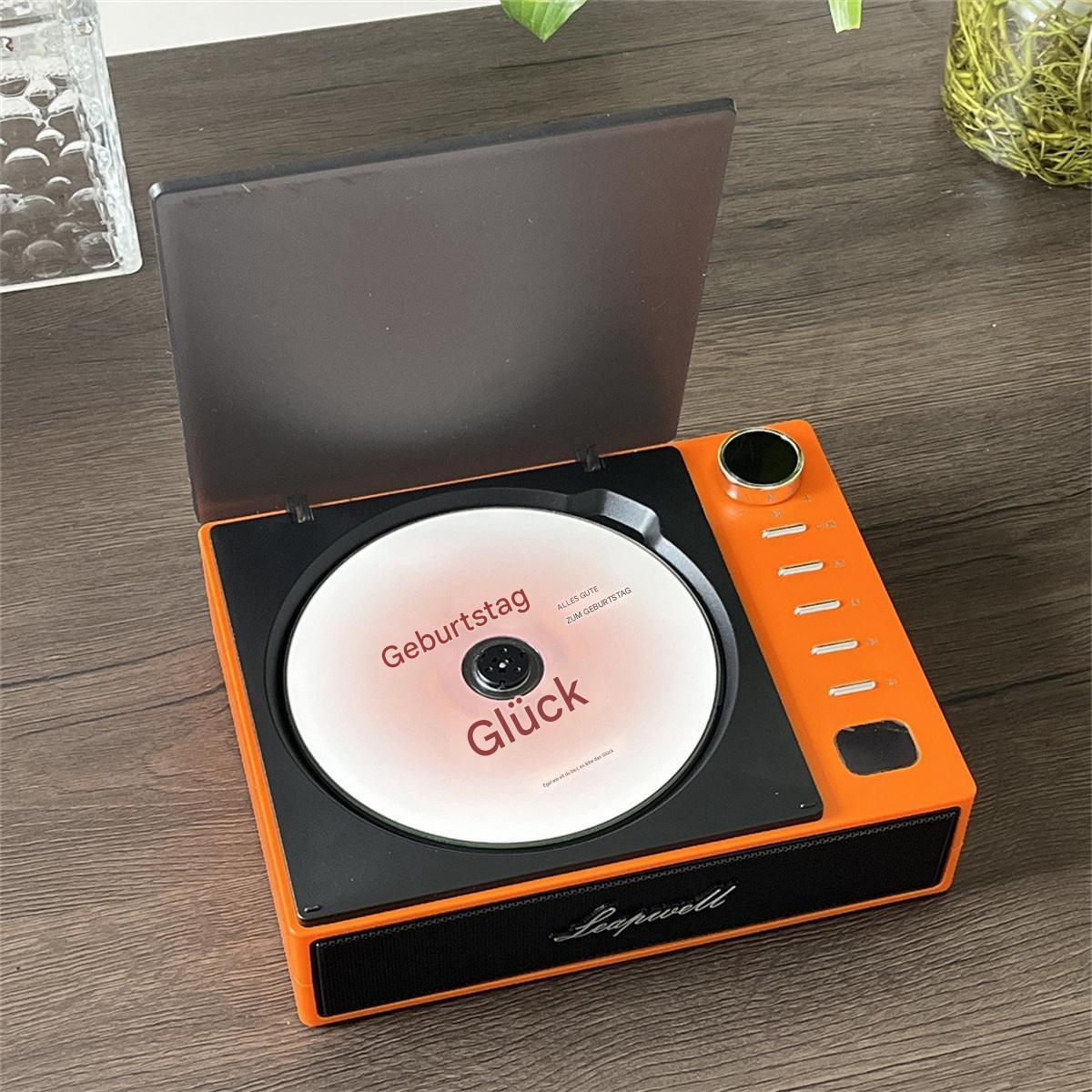 Oranger Retro-CD-Player mit einer eingelegten Disc. Die Disc hat deutschen Text.