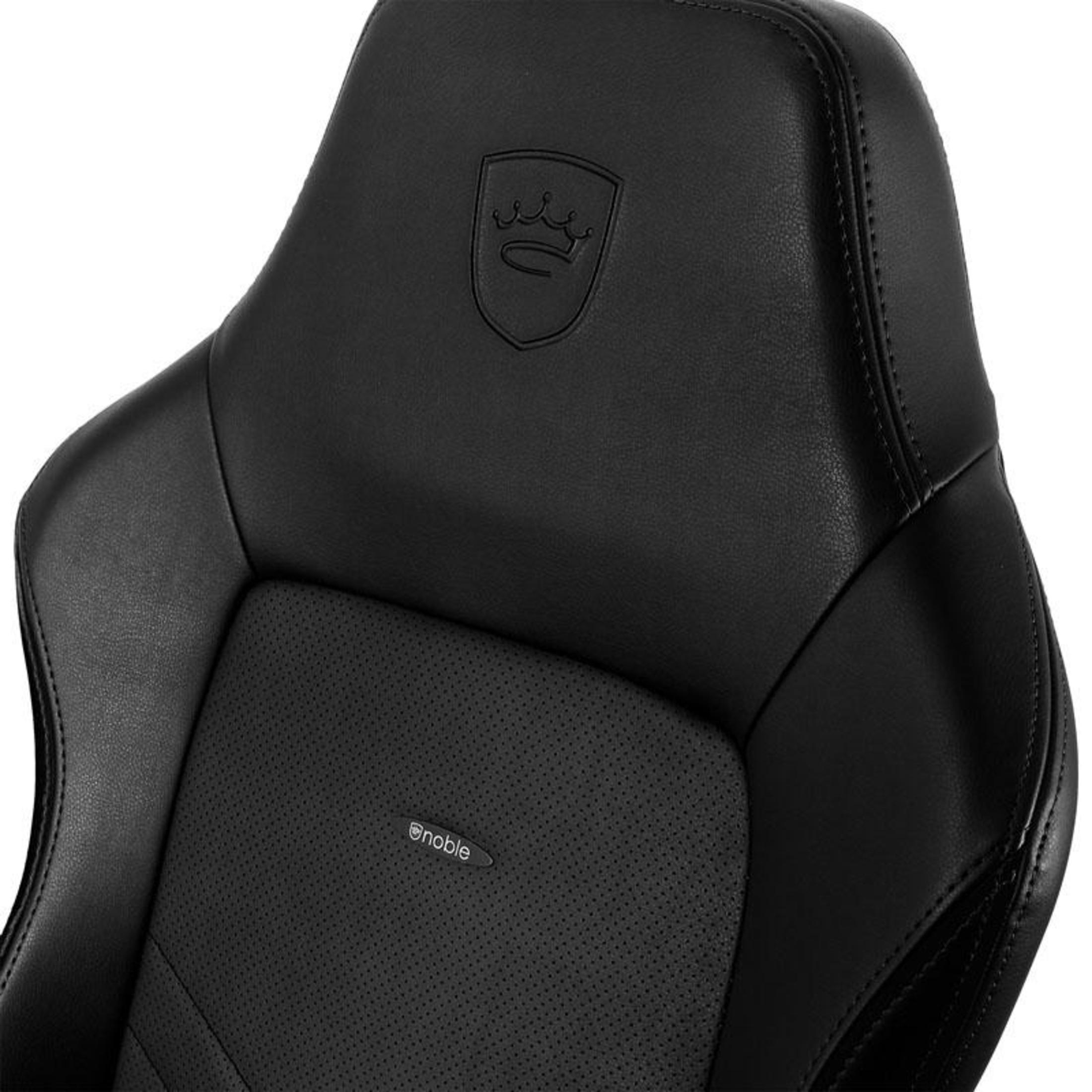 Nahaufnahme der Kopfstütze und des oberen Rückens eines schwarzen Gaming-Stuhls. Merkmale: geprägtes Logo und perforierte Lederstruktur.