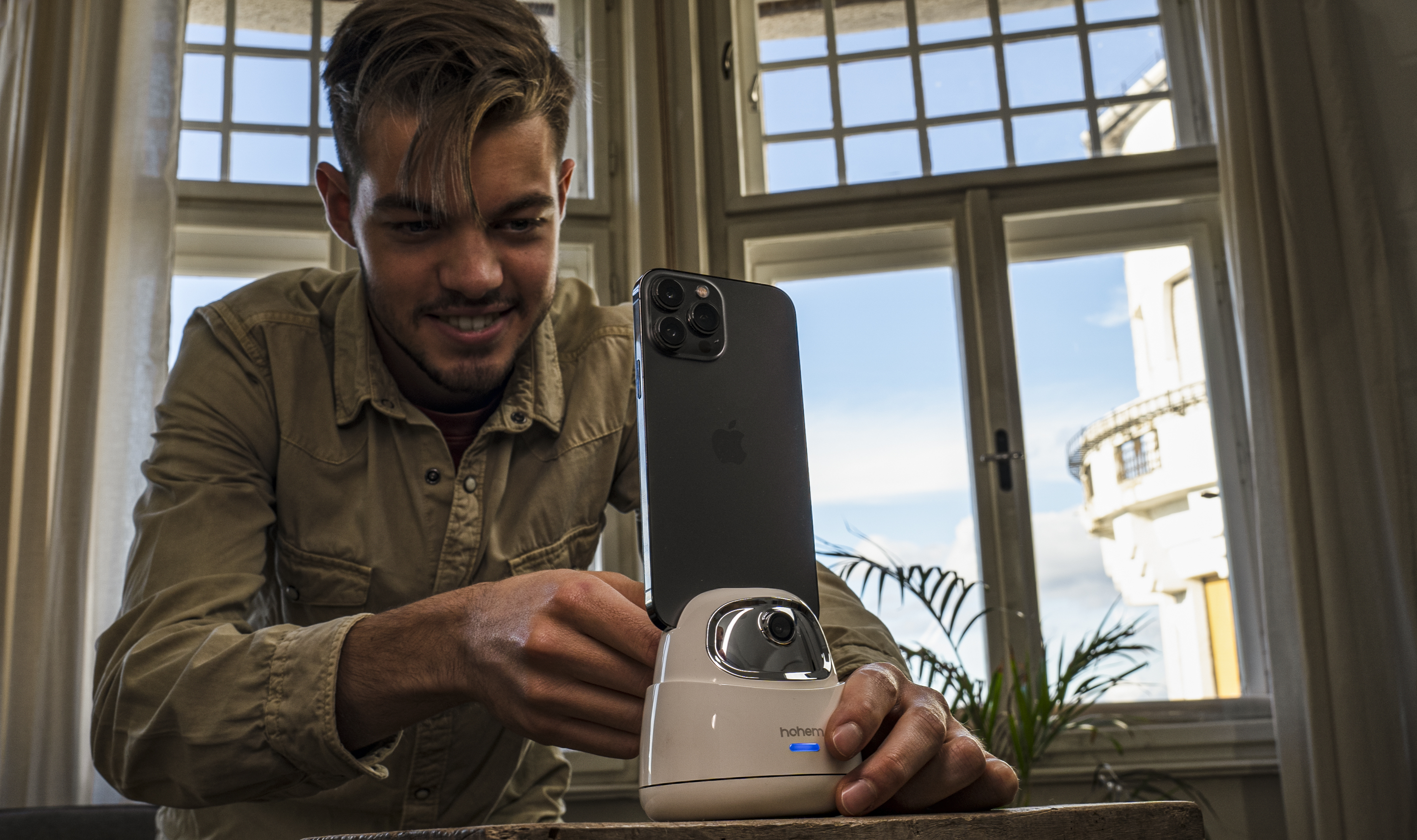 Ein Mann mit einem Telefon auf einem Ständer. Dahinter ein Fenster.