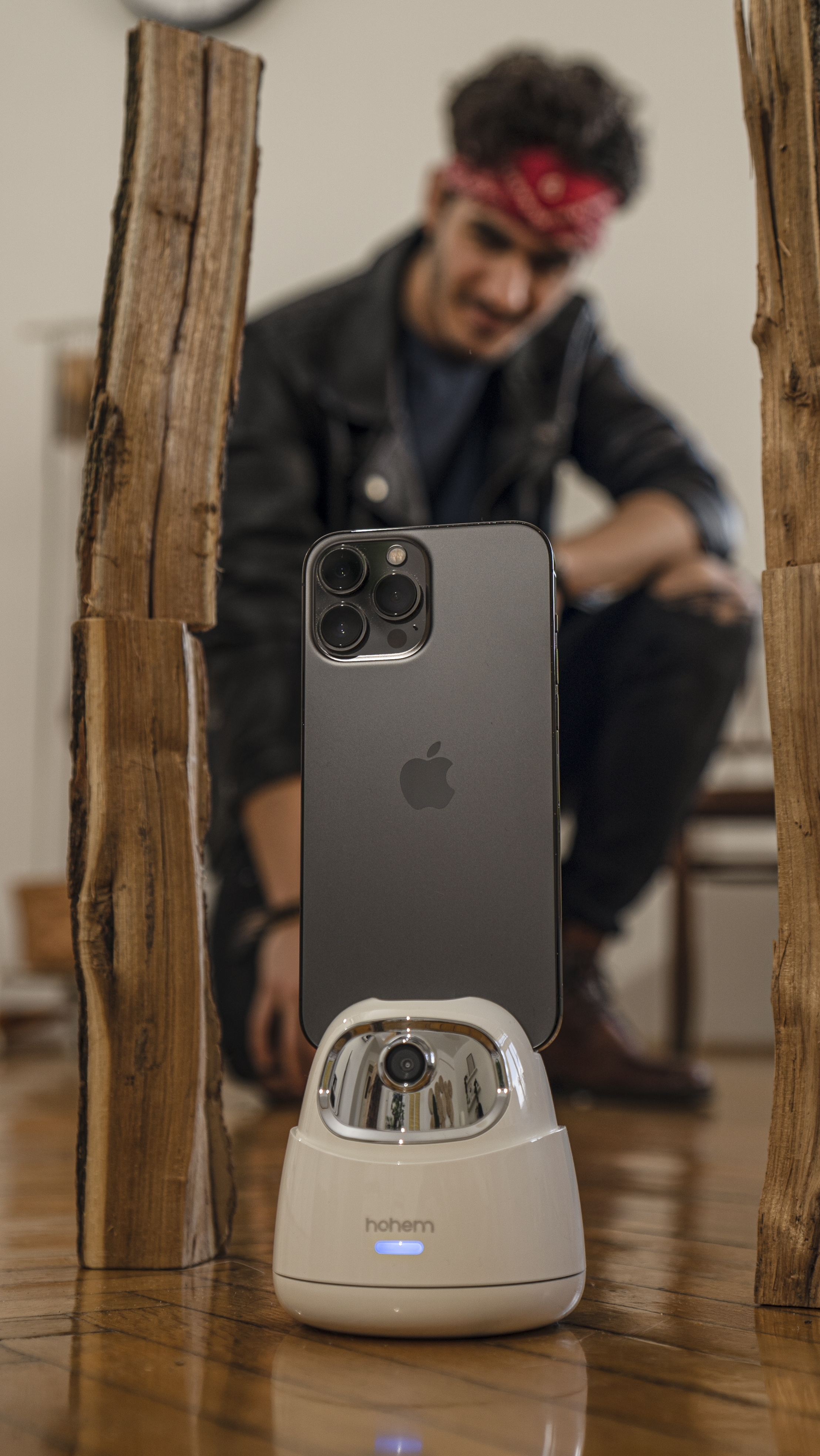 Ein Telefon auf einem weißen Ständer zwischen Holzpfosten. Ein Mann ist im Hintergrund unscharf.