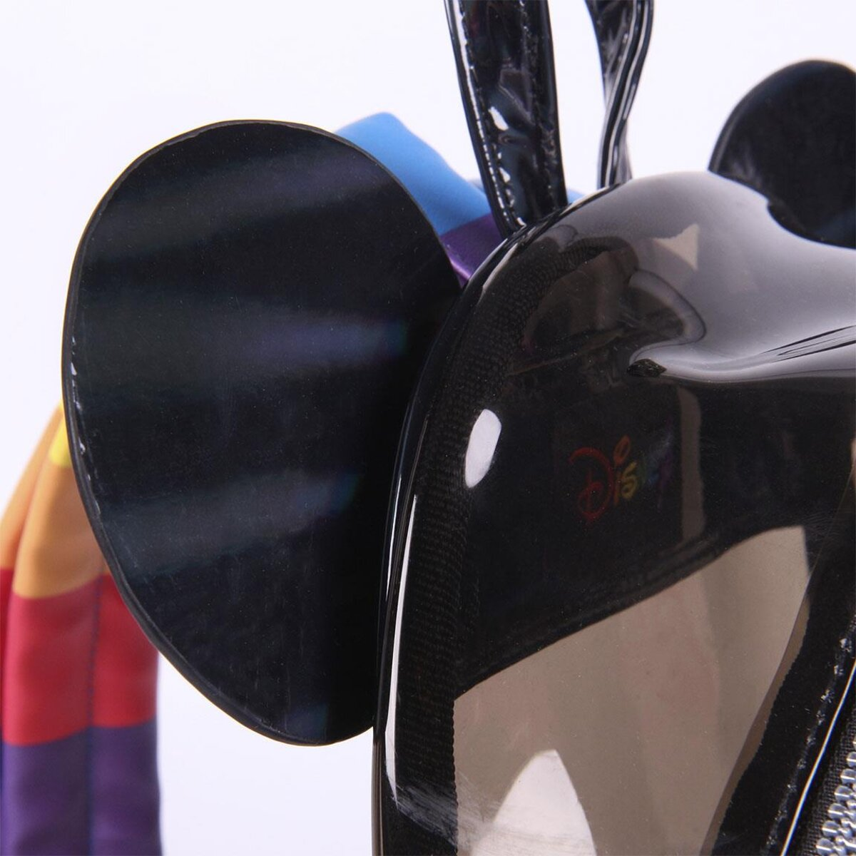 Primer plano de las orejas de Mickey Mouse en una mochila negra transparente. El logotipo de Disney también es parcialmente visible.